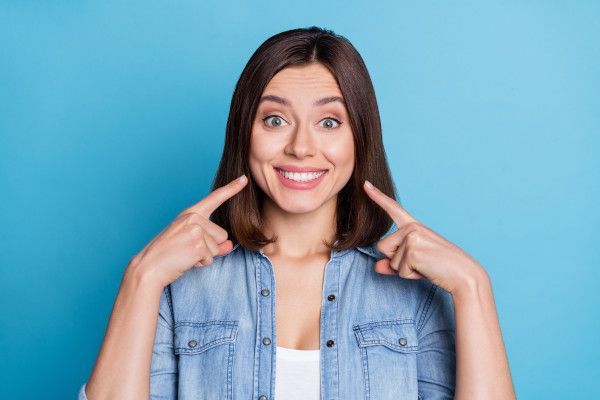 Eine Frau zeigt ihre Zähne nach erfolgreichem Bleaching