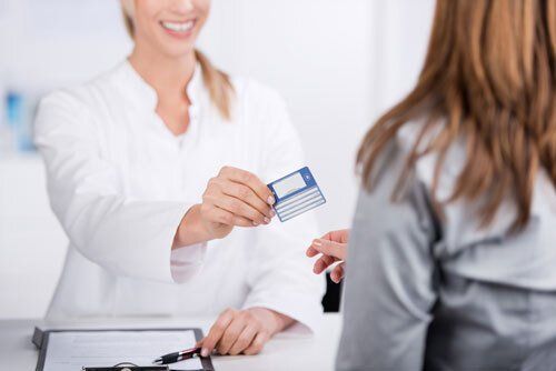 Patientin übergibt Krankenkassen-Karte