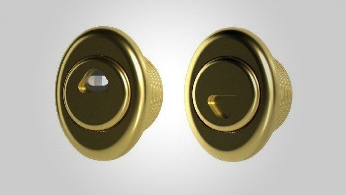 Due serrature per porte color oro montate una accanto all'altra su uno sfondo chiaro