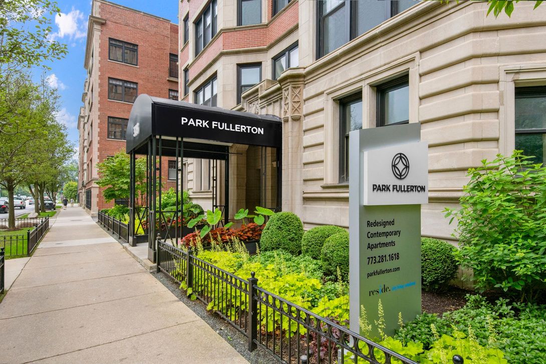 A large apartment building with a sign in front of it at Park Fullerton by Reside.