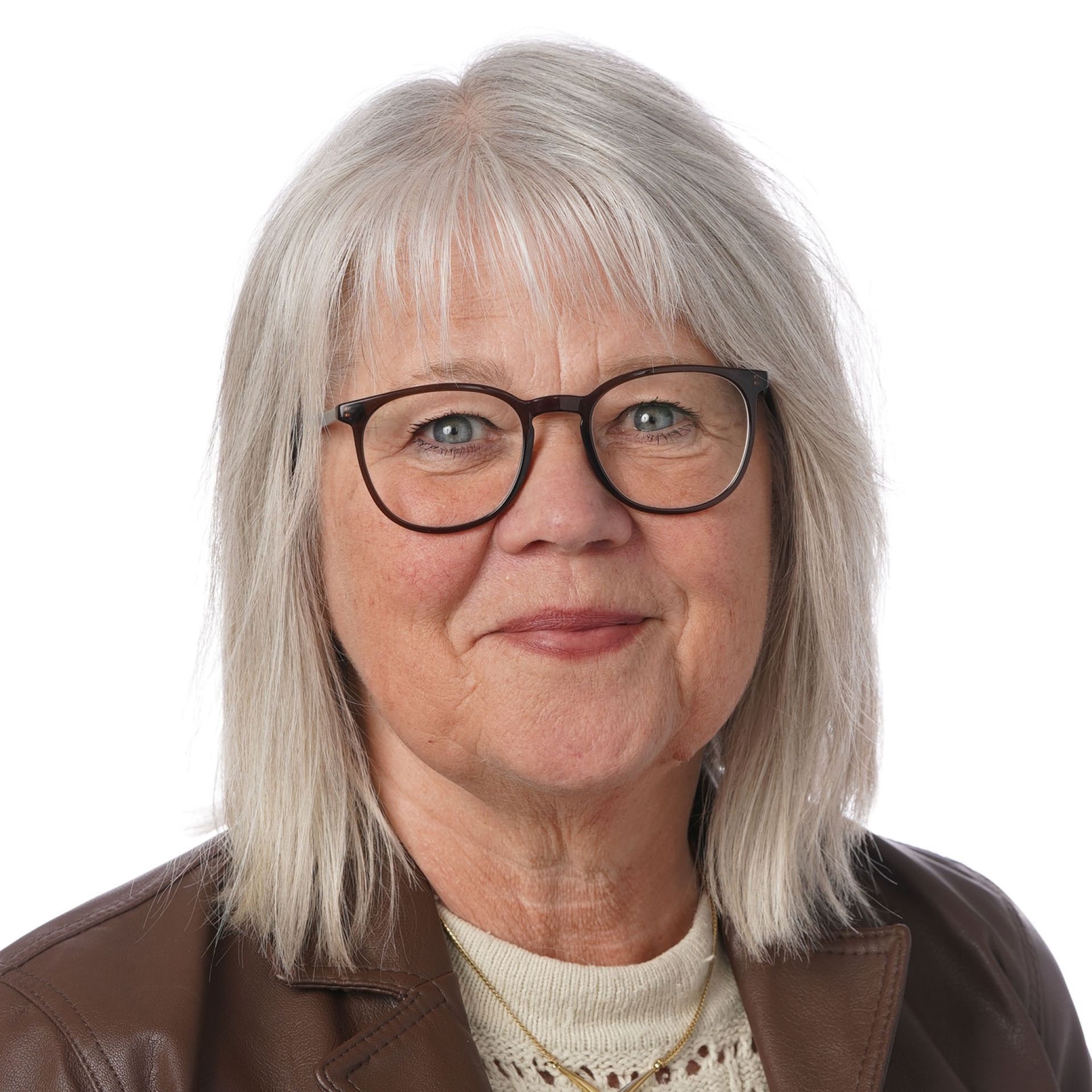 Kvinde med gråt hår og briller, smilende, iført en lys sweater over en blå skjorte.