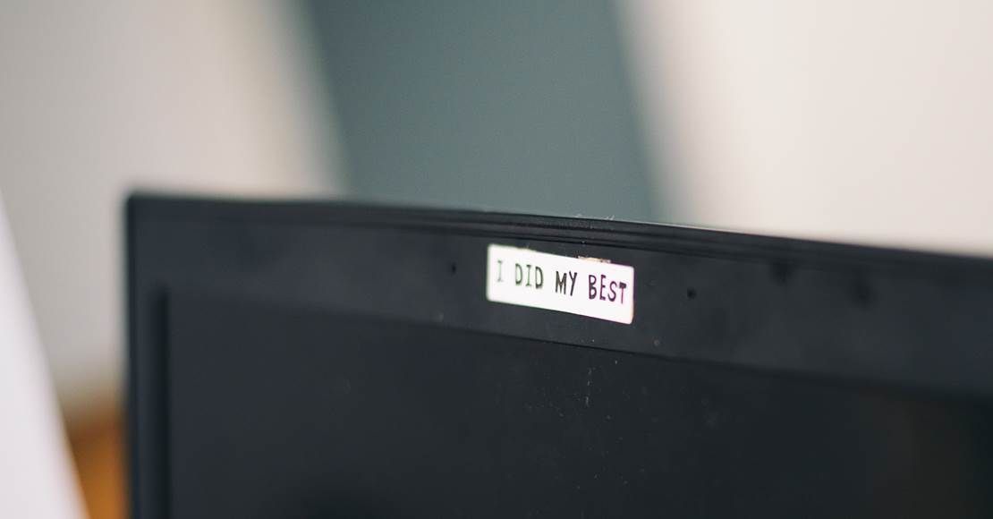 Bærbar computer med et hvidt klistermærke, der dækker webcammet.