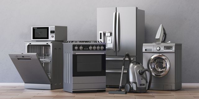 A group of stainless steel appliances are sitting on a wooden floor.