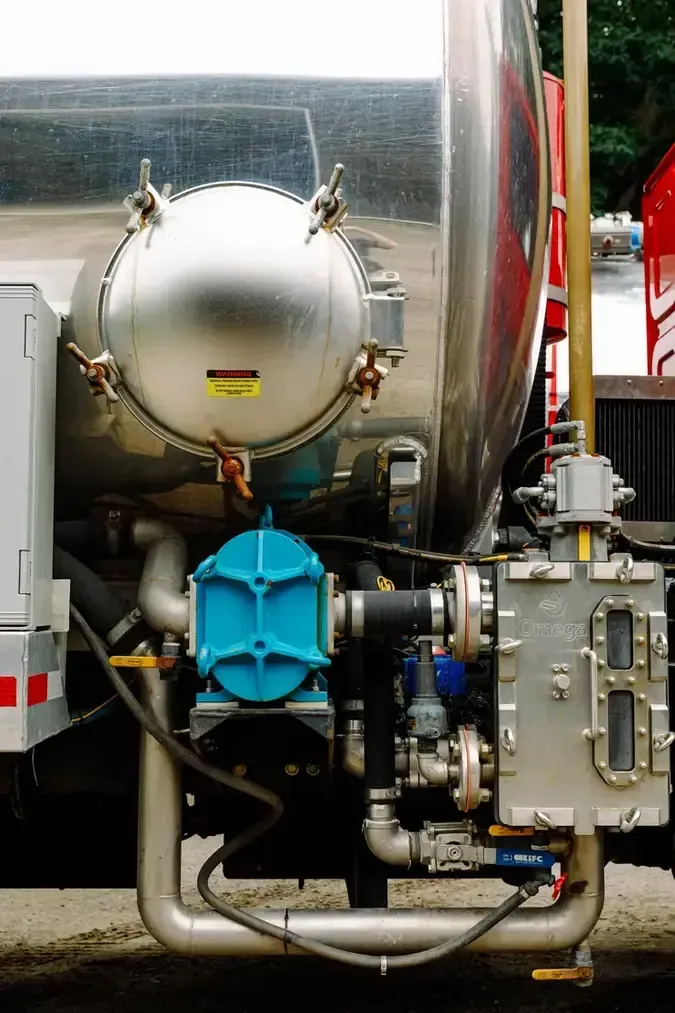 A stainless steel tank with a blue pump attached to it.