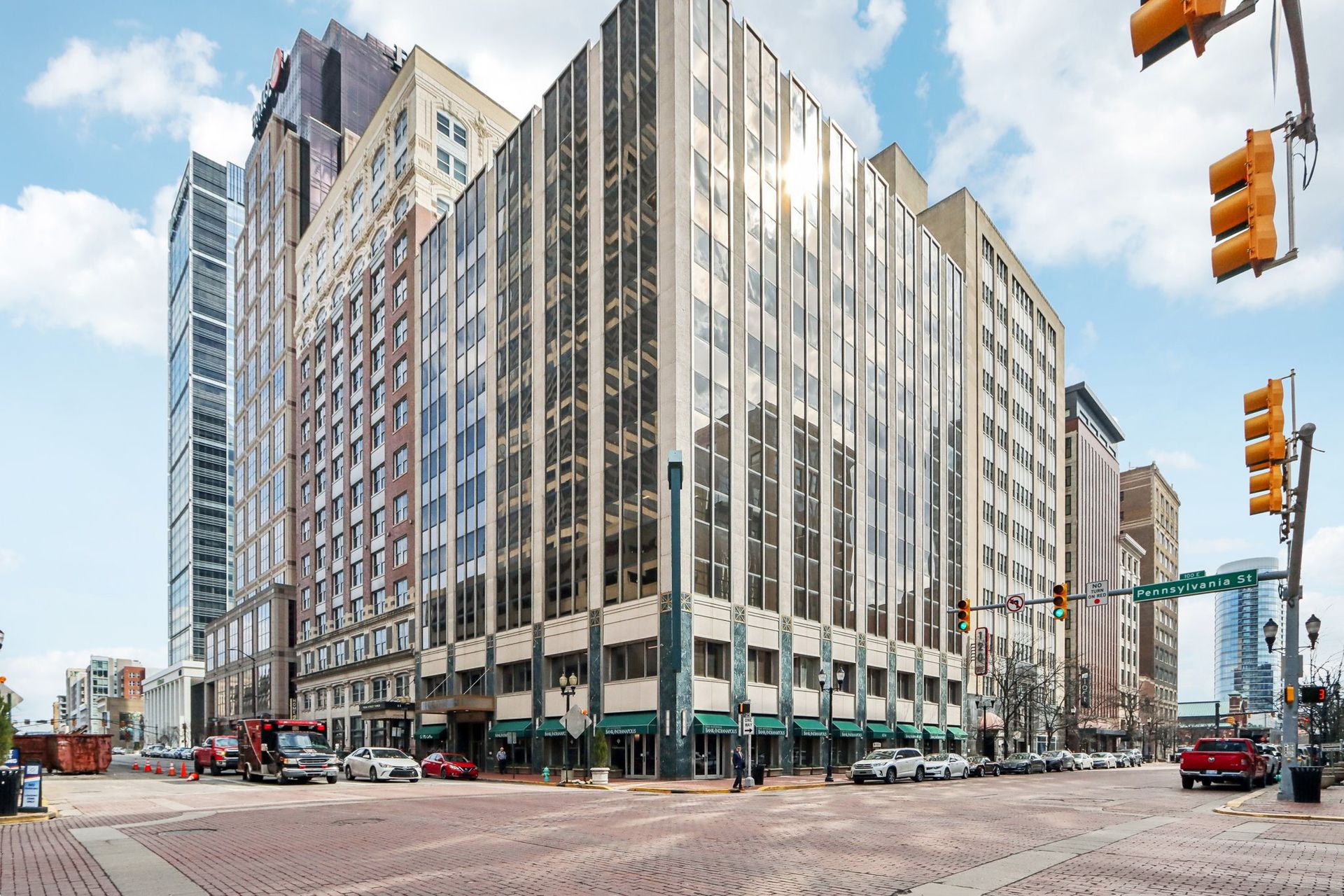 A large building is sitting on the corner of a city street.