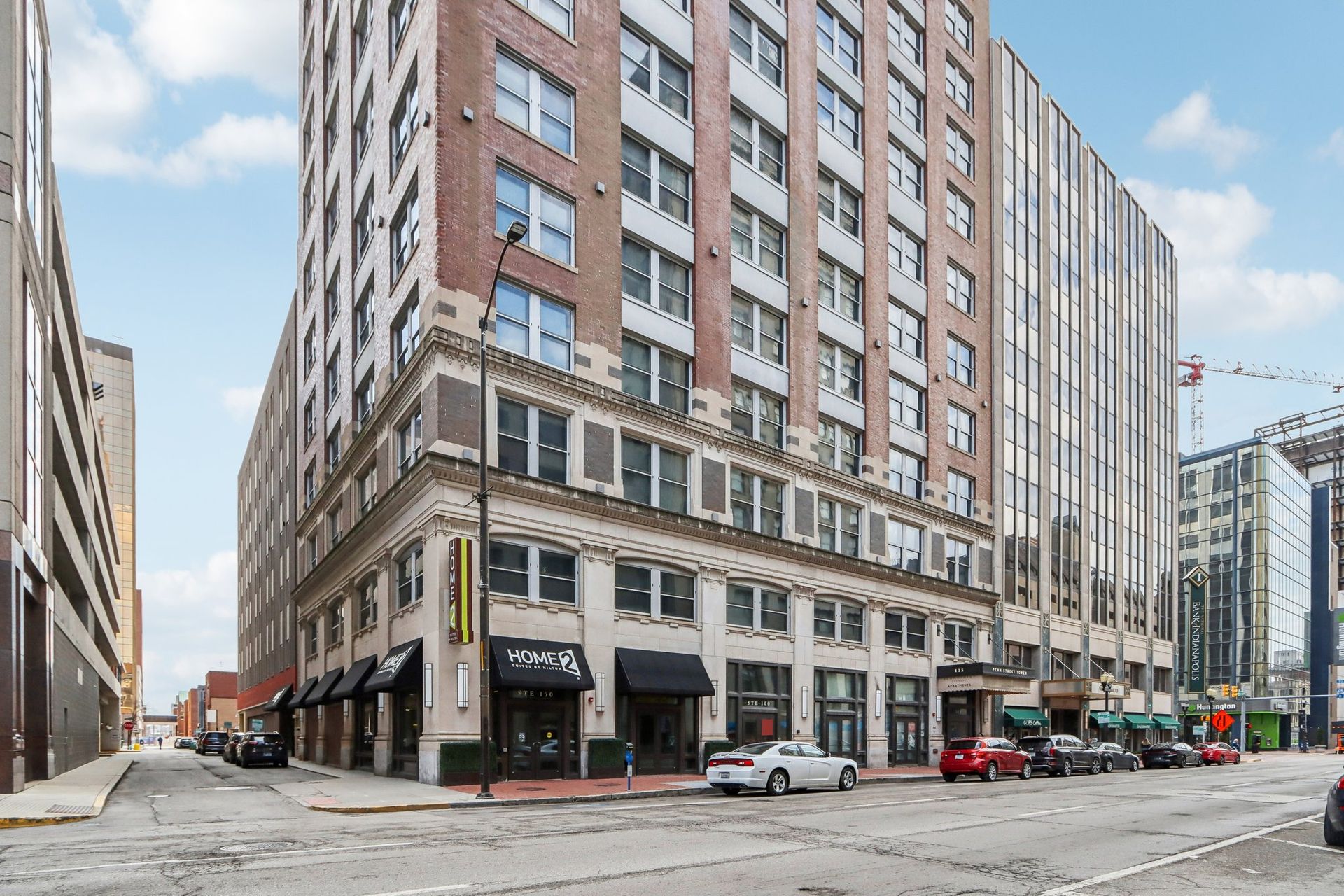 A large brick building is on the corner of a city street.