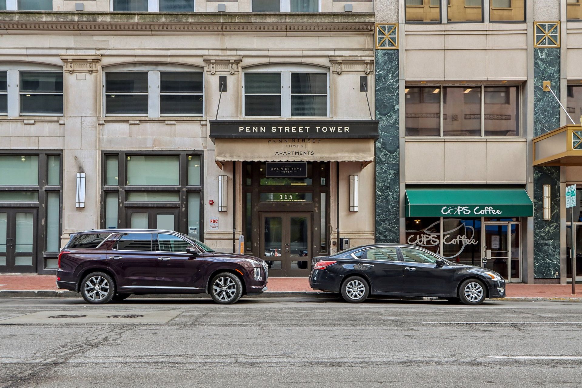 Two cars are parked in front of a building.