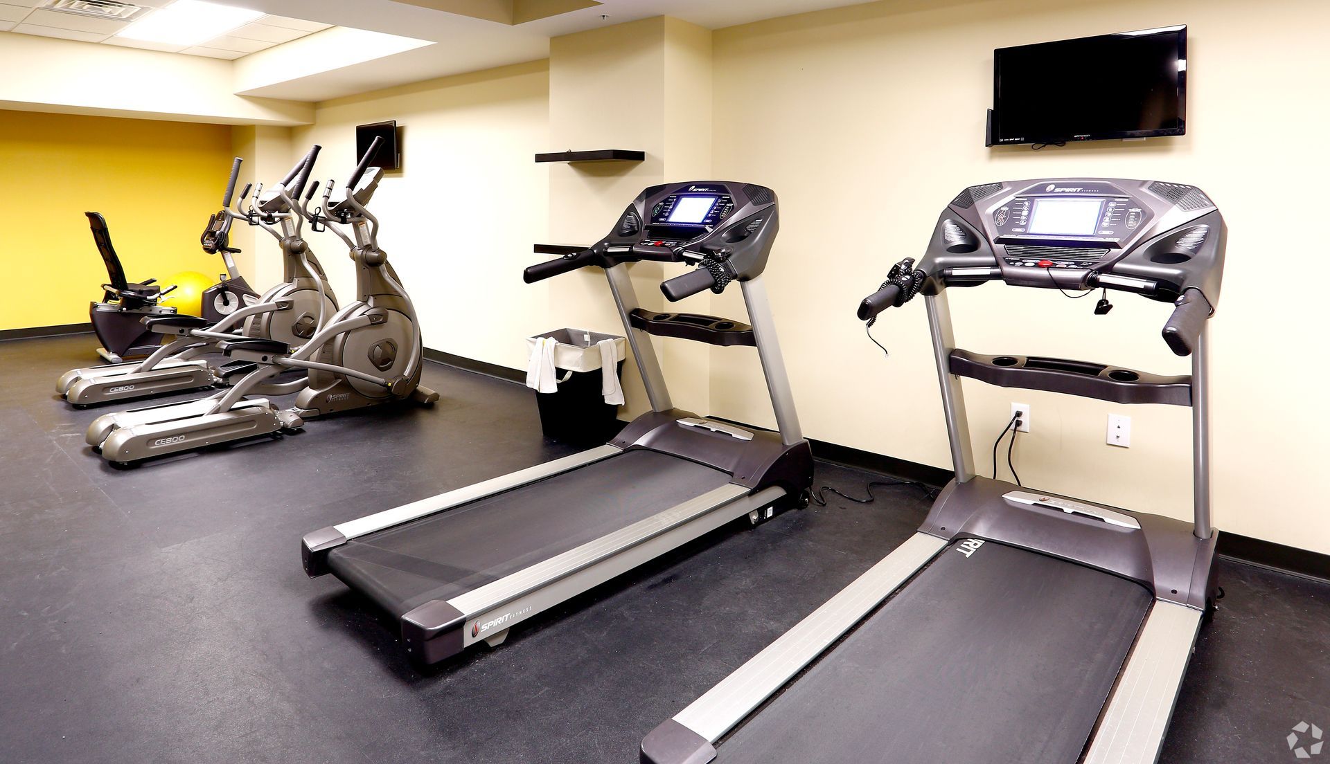 A gym with a lot of treadmills and exercise bikes