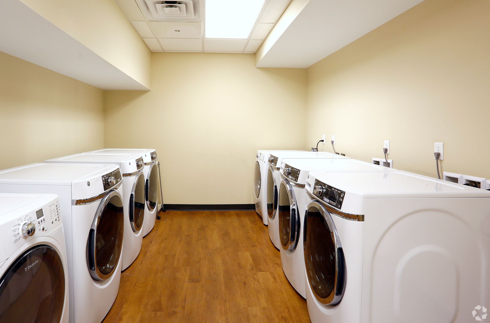 A laundry room with a lot of washers and dryers