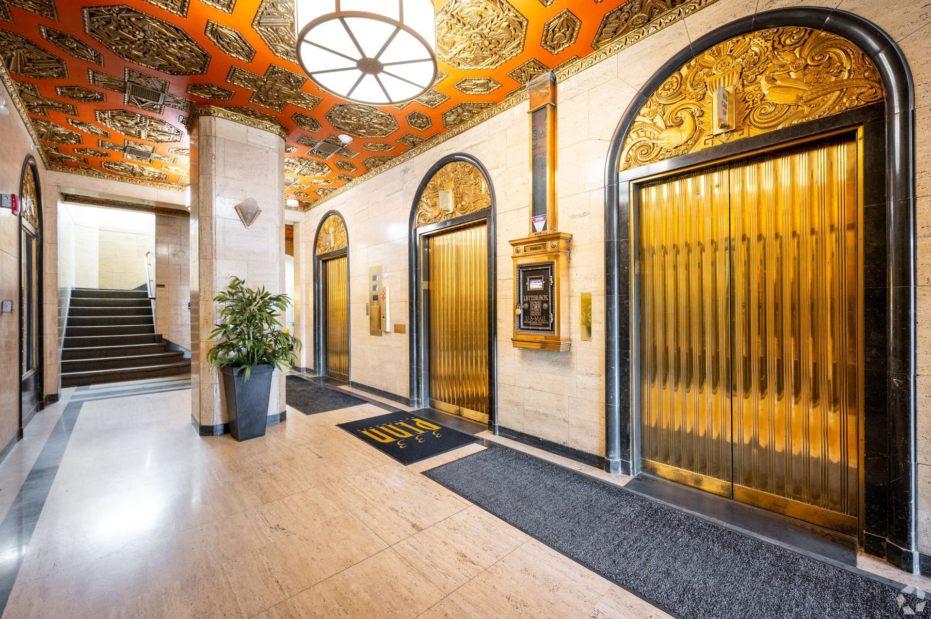 A hallway with elevators and stairs in a building.