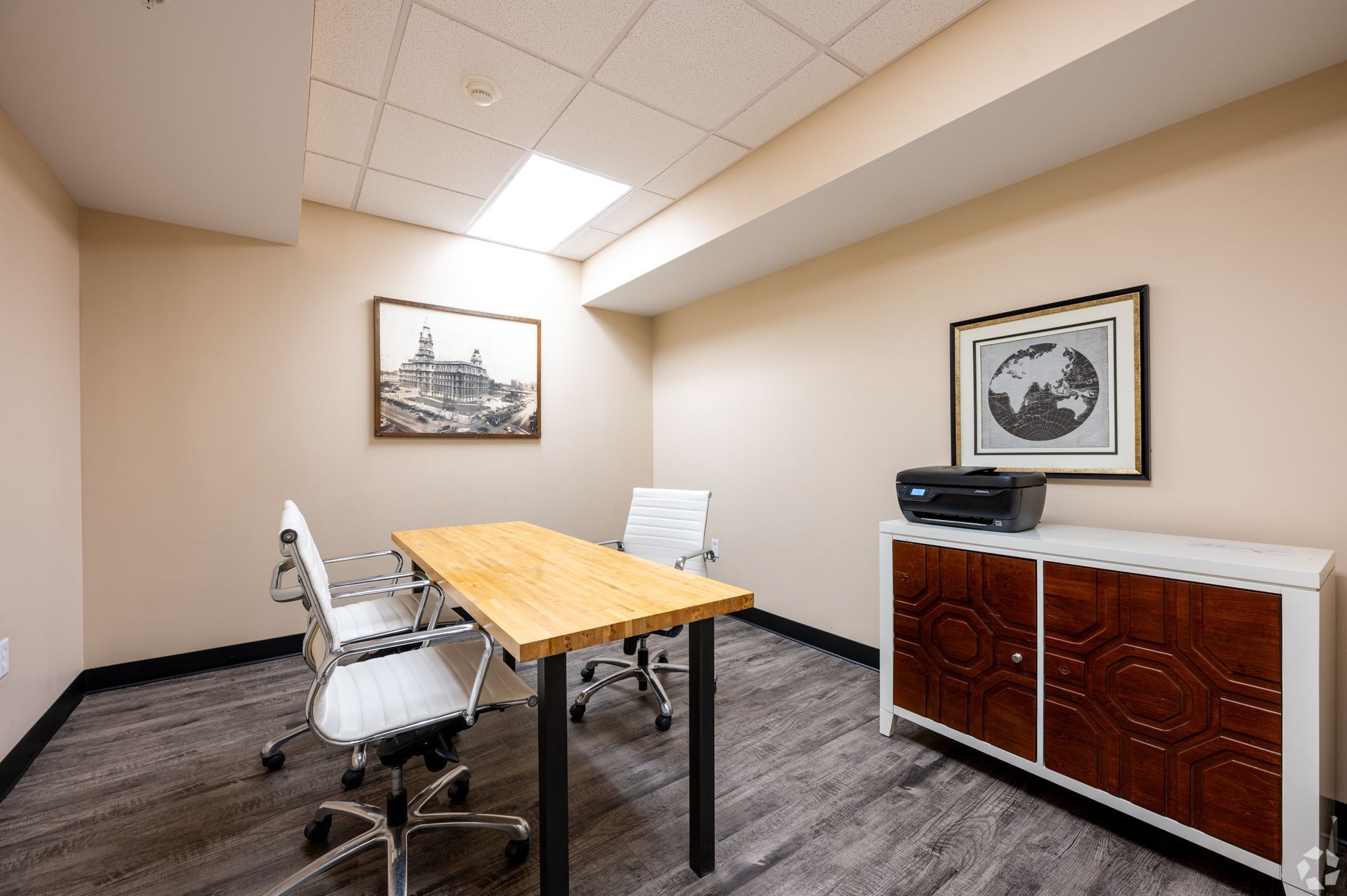 A conference room with a table and chairs and a printer.