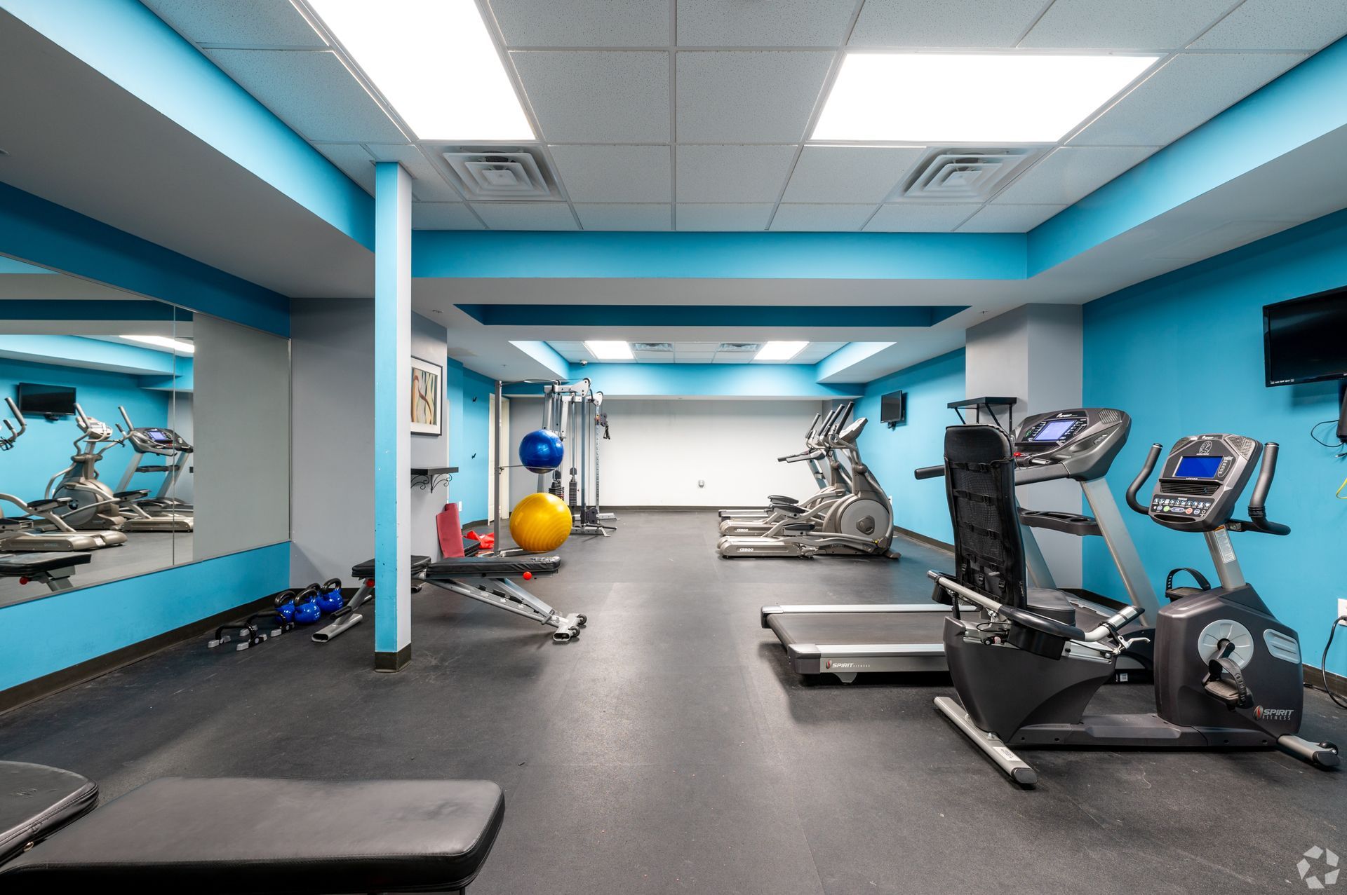 A gym with blue walls and a lot of equipment