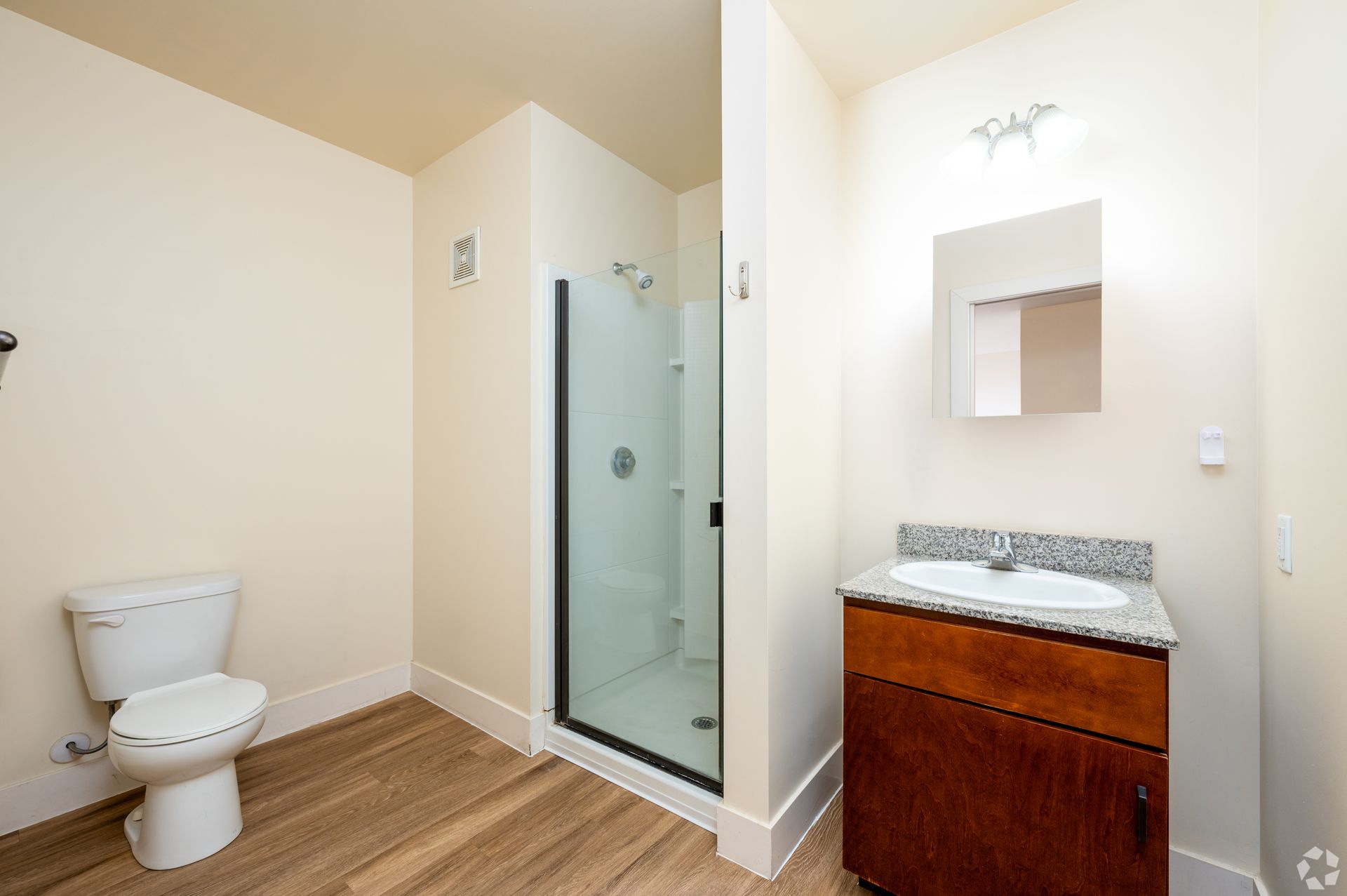 A bathroom with a toilet , sink , and walk in shower.