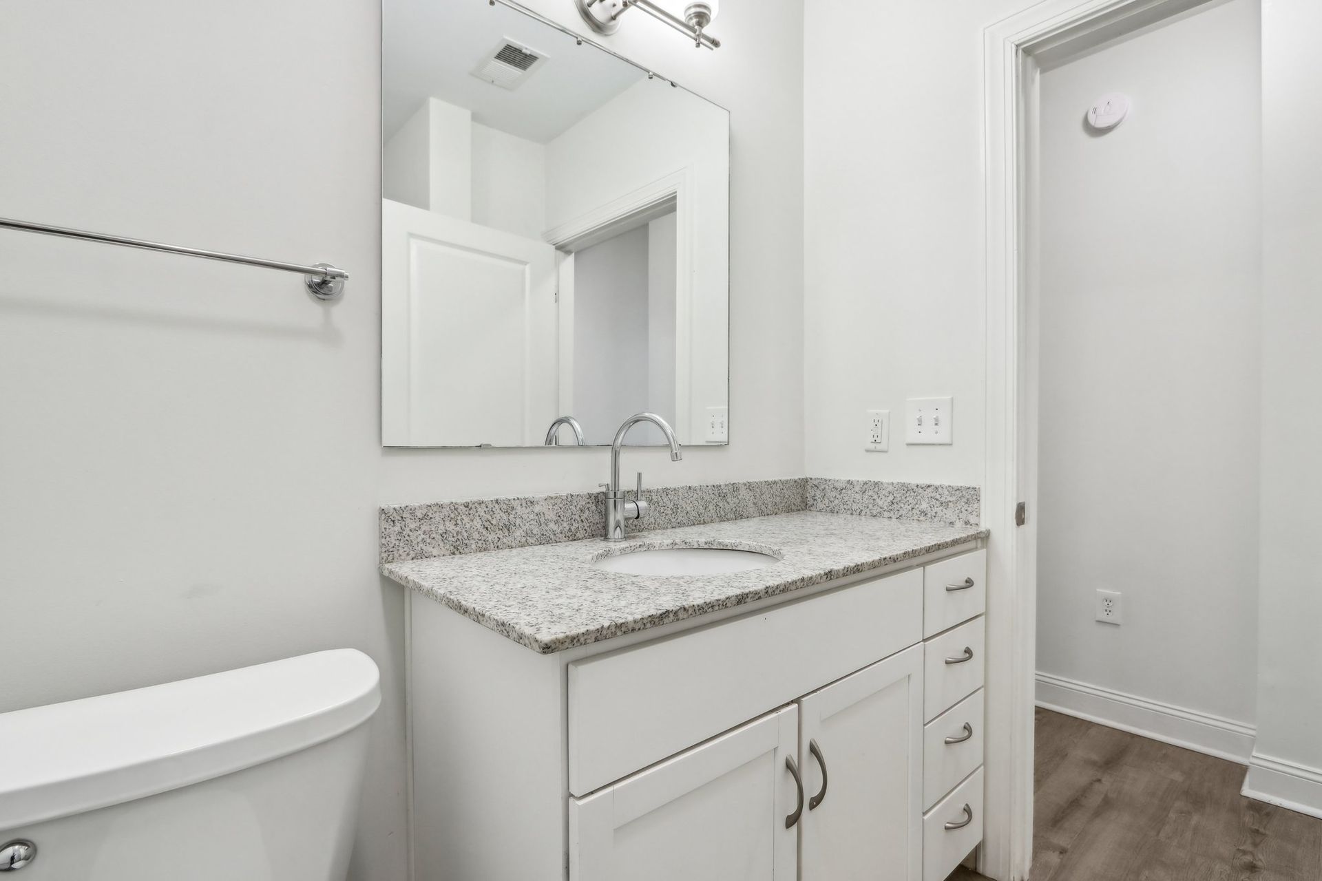 A bathroom with a sink , toilet and mirror.
