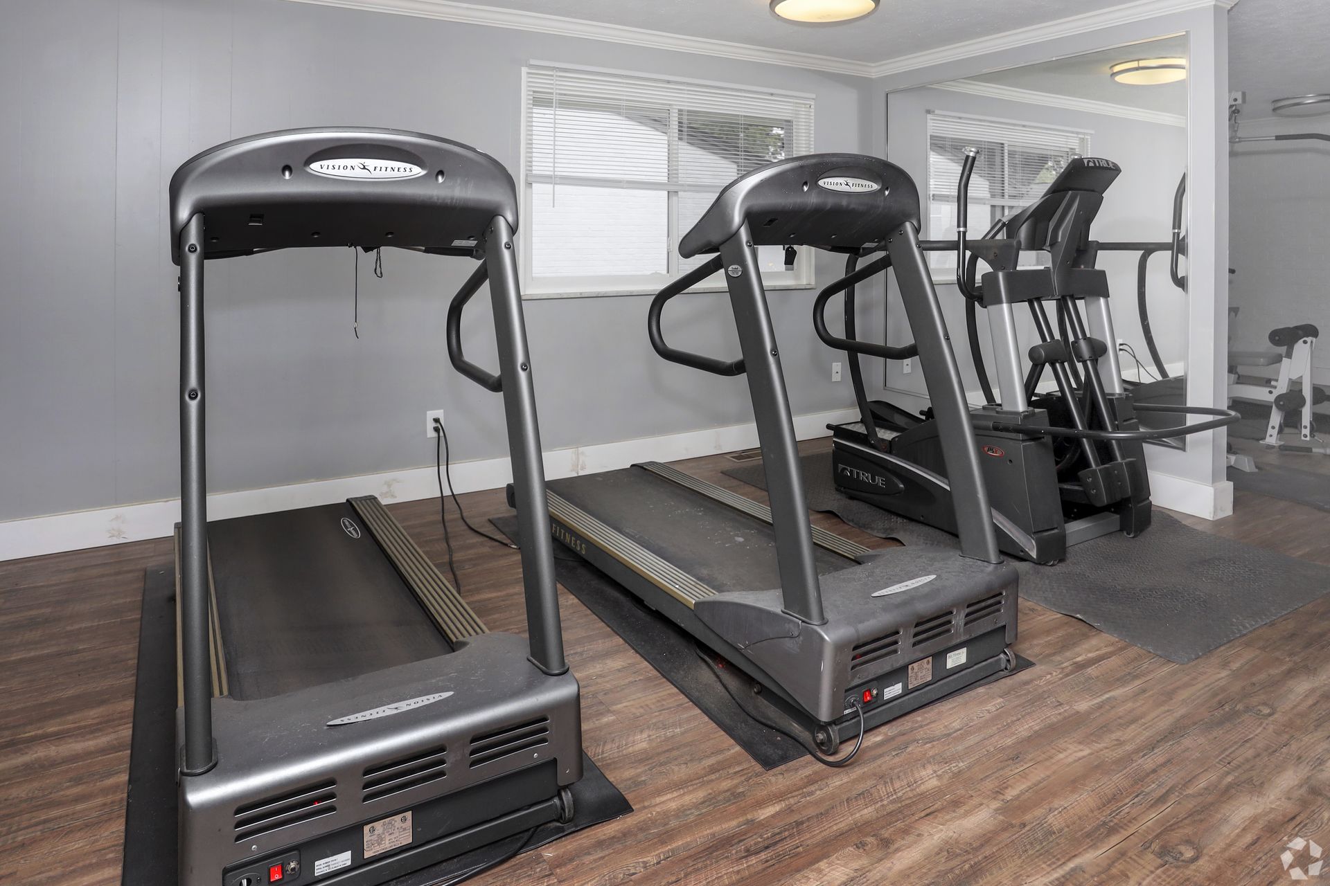 Two treadmills are sitting next to each other in a gym.
