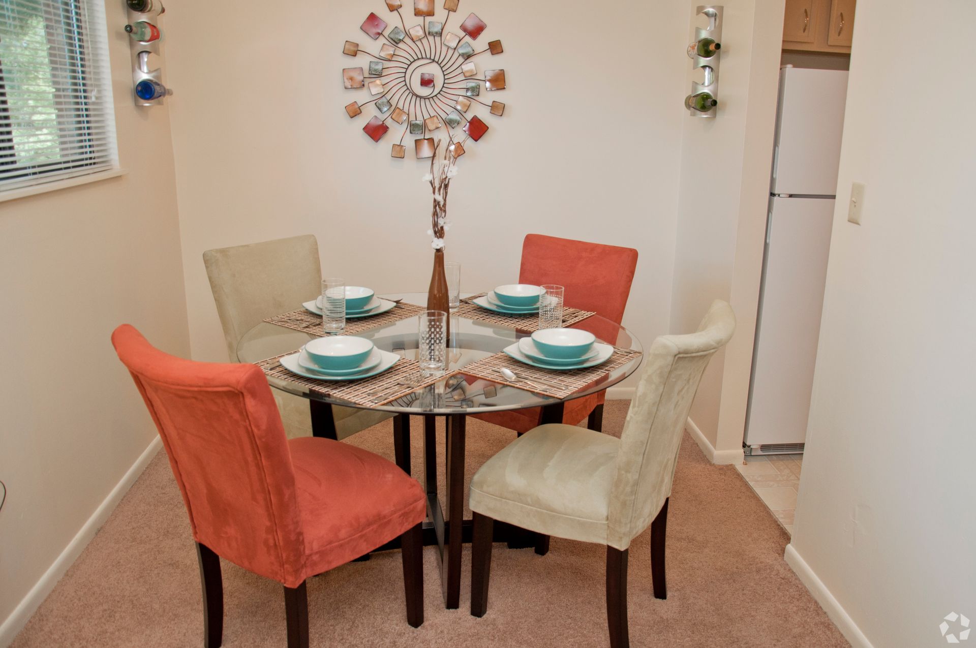 A dining room with a table and chairs and plates on it