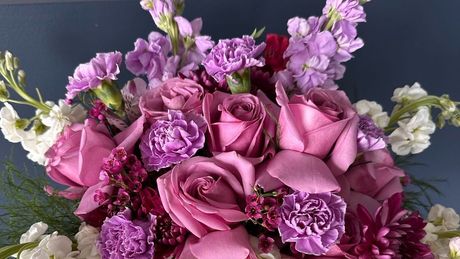 A person is arranging flowers in a vase on a table. A person is arranging flowers in a vase on a table.