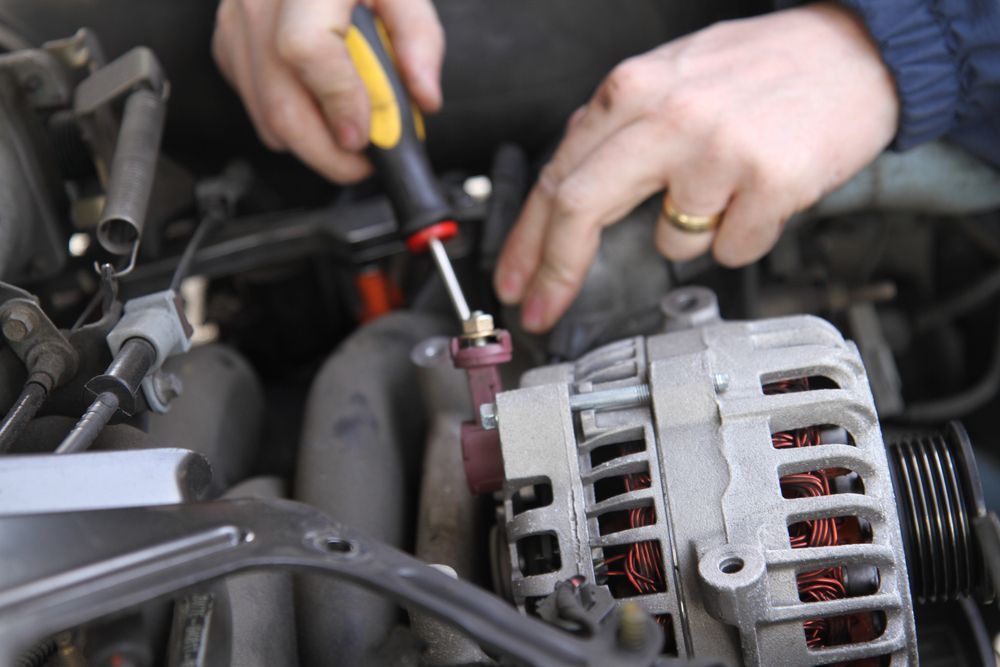 A Person is Working on a Car Alternator With a Screwdriver — JJ's Garage In South Geelong, VIC