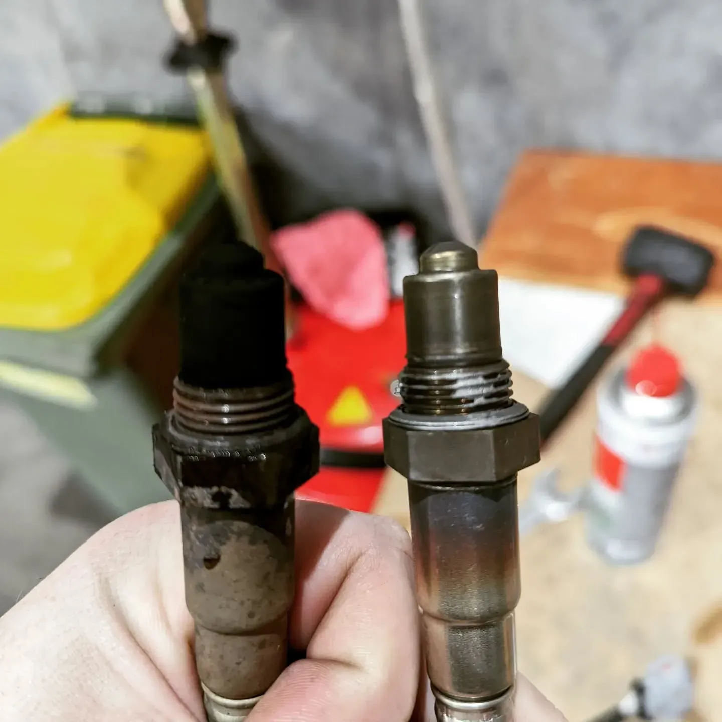 A Person is Holding Two Spark Plugs in Their Hand — JJ's Garage In South Geelong, VIC