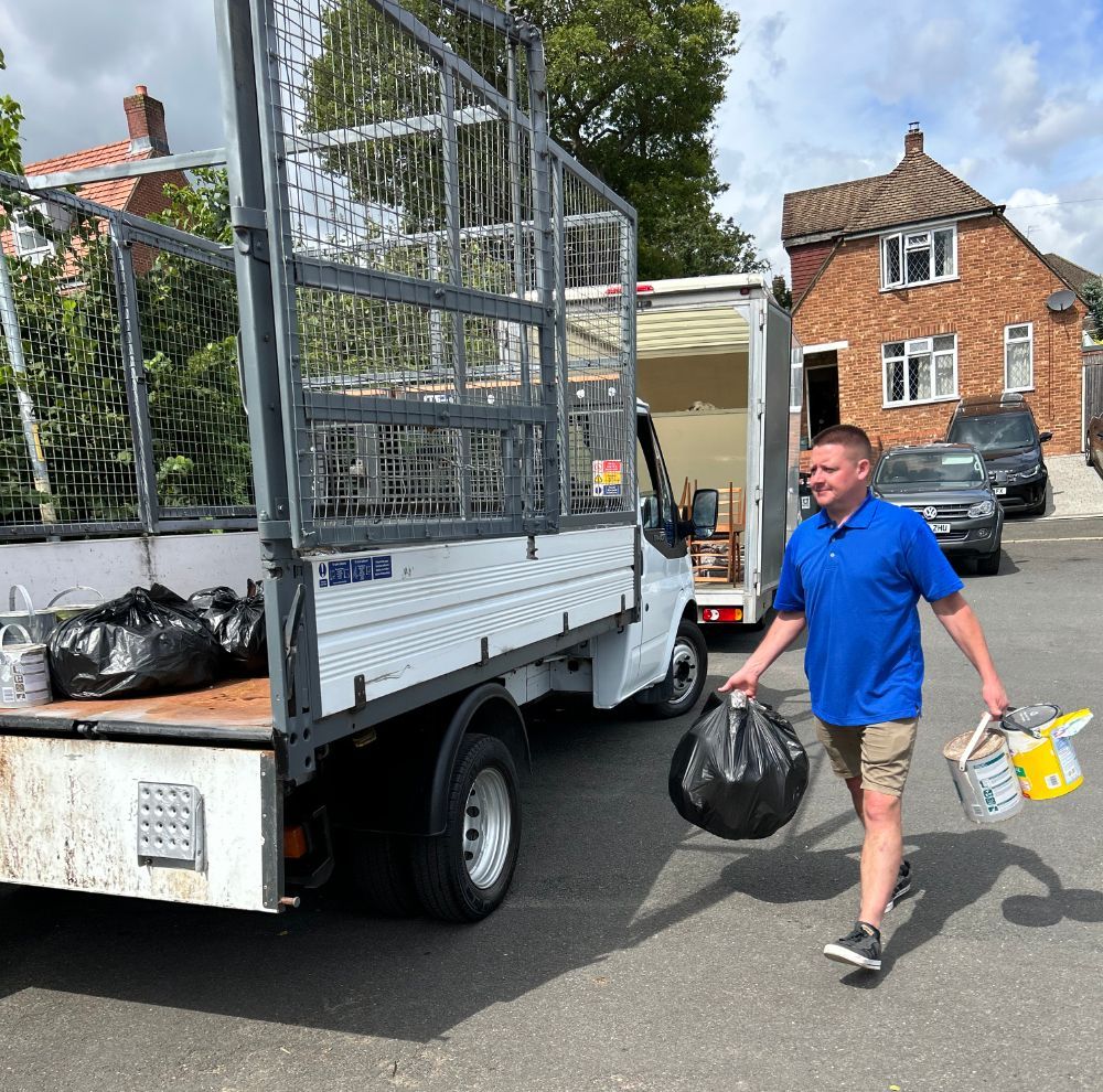 A Kings House Clearance workman in a blue shirt is walking towards a truck