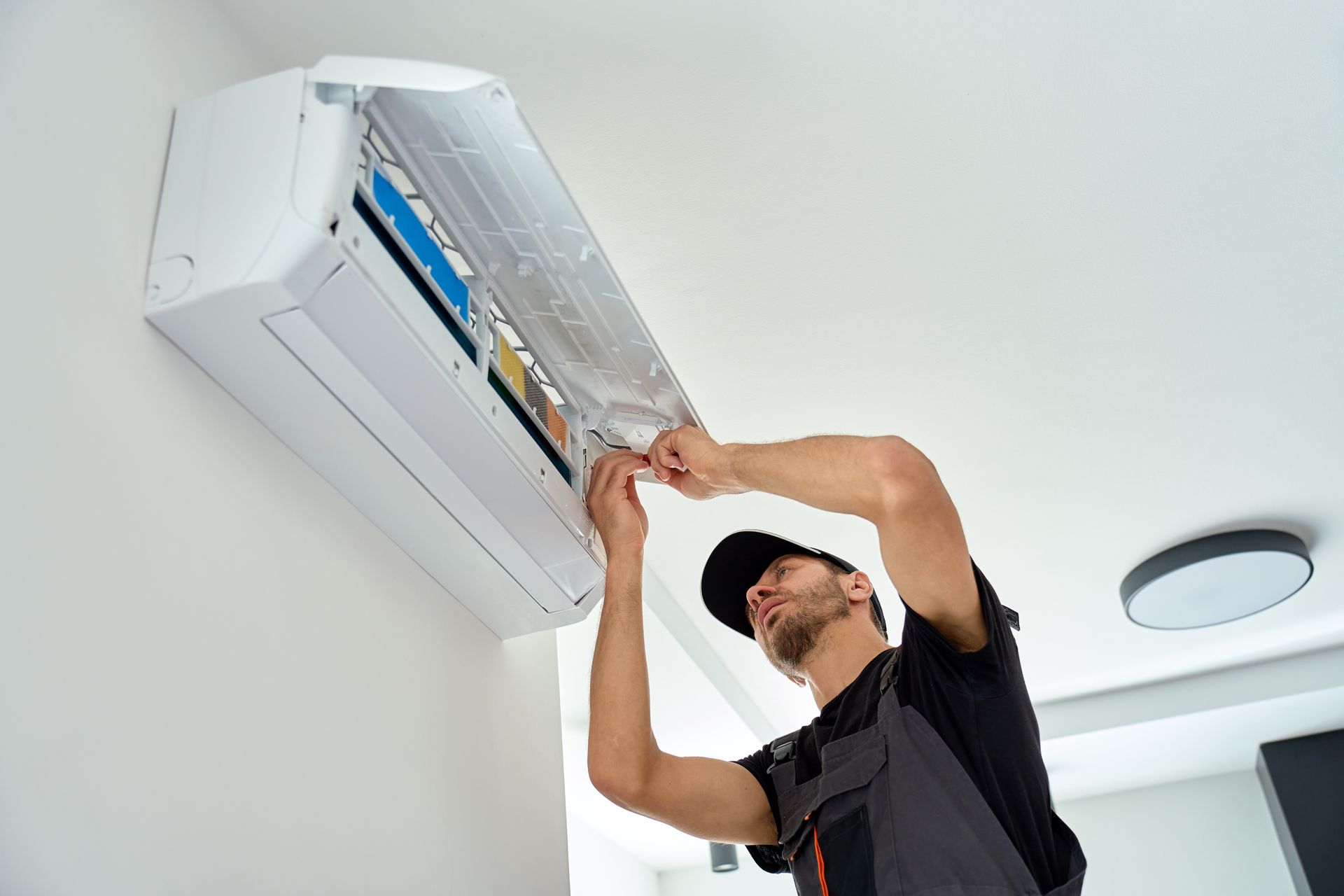 A technician servicing an air conditioner at home.