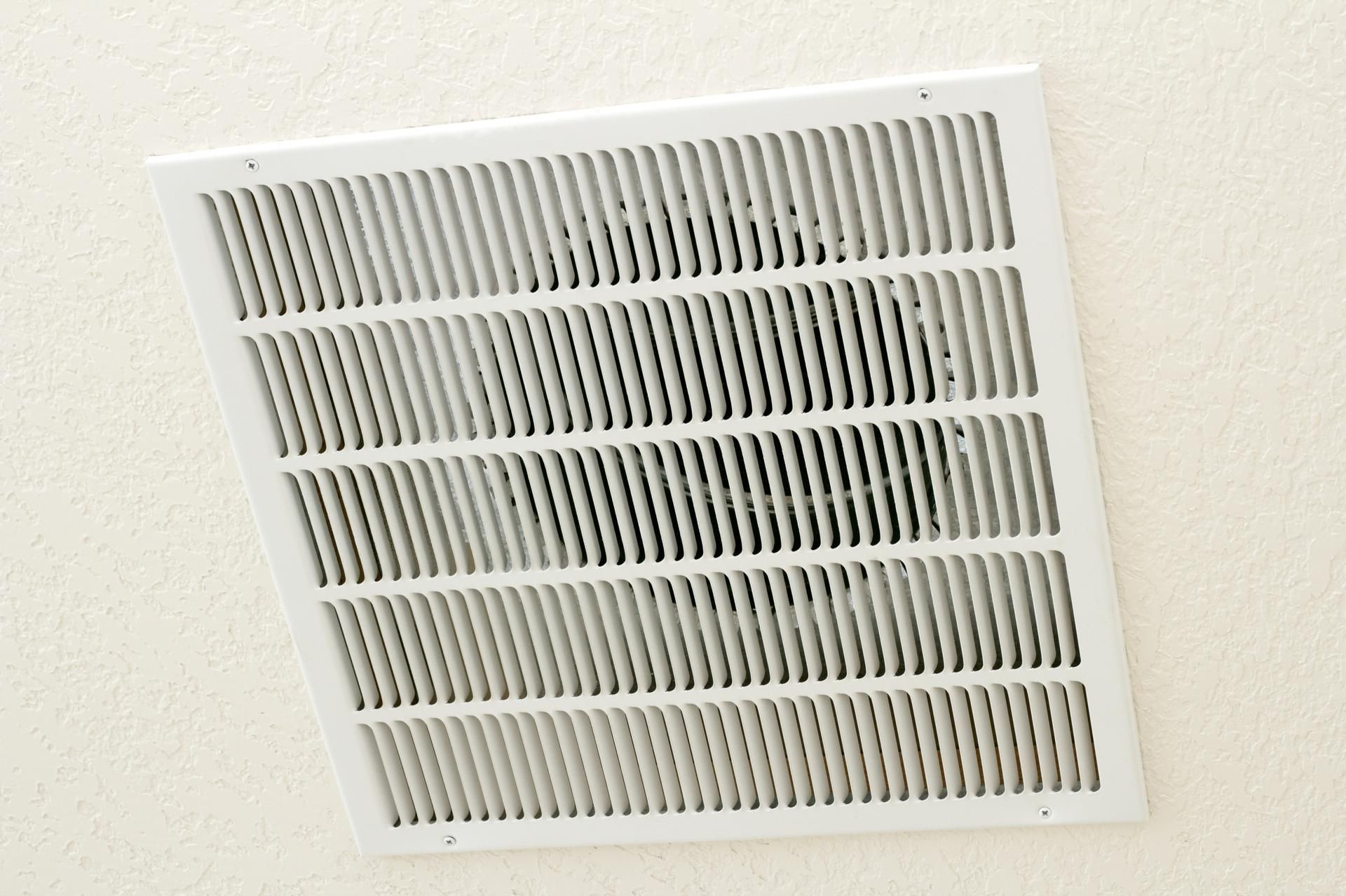 A white air vent on a white wall