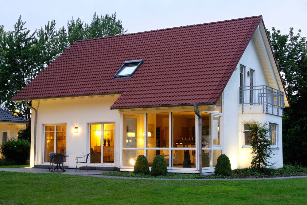A white house with a red roof and a skylight
