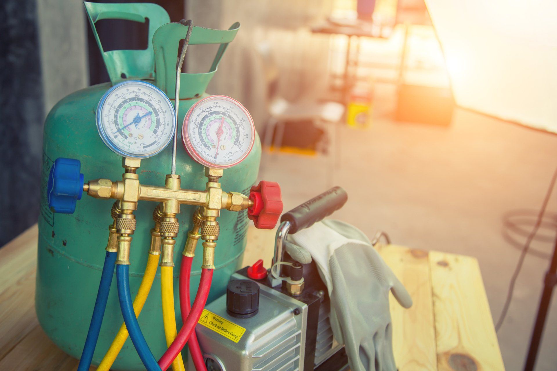 Gas cylinder with pressure gauges and colored hoses in a workshop setting