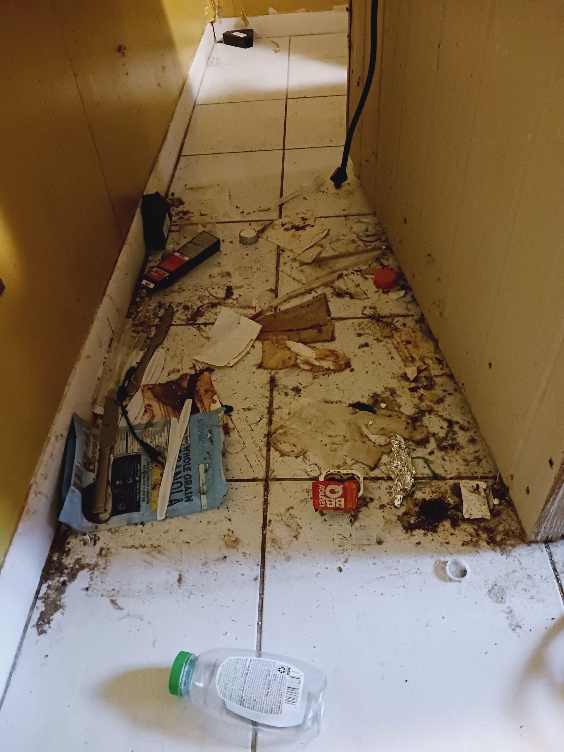 A dirty hallway with a bottle of water on the floor