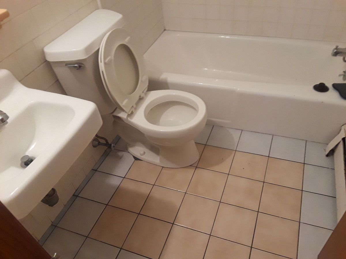 A bathroom with a toilet a sink and a bathtub