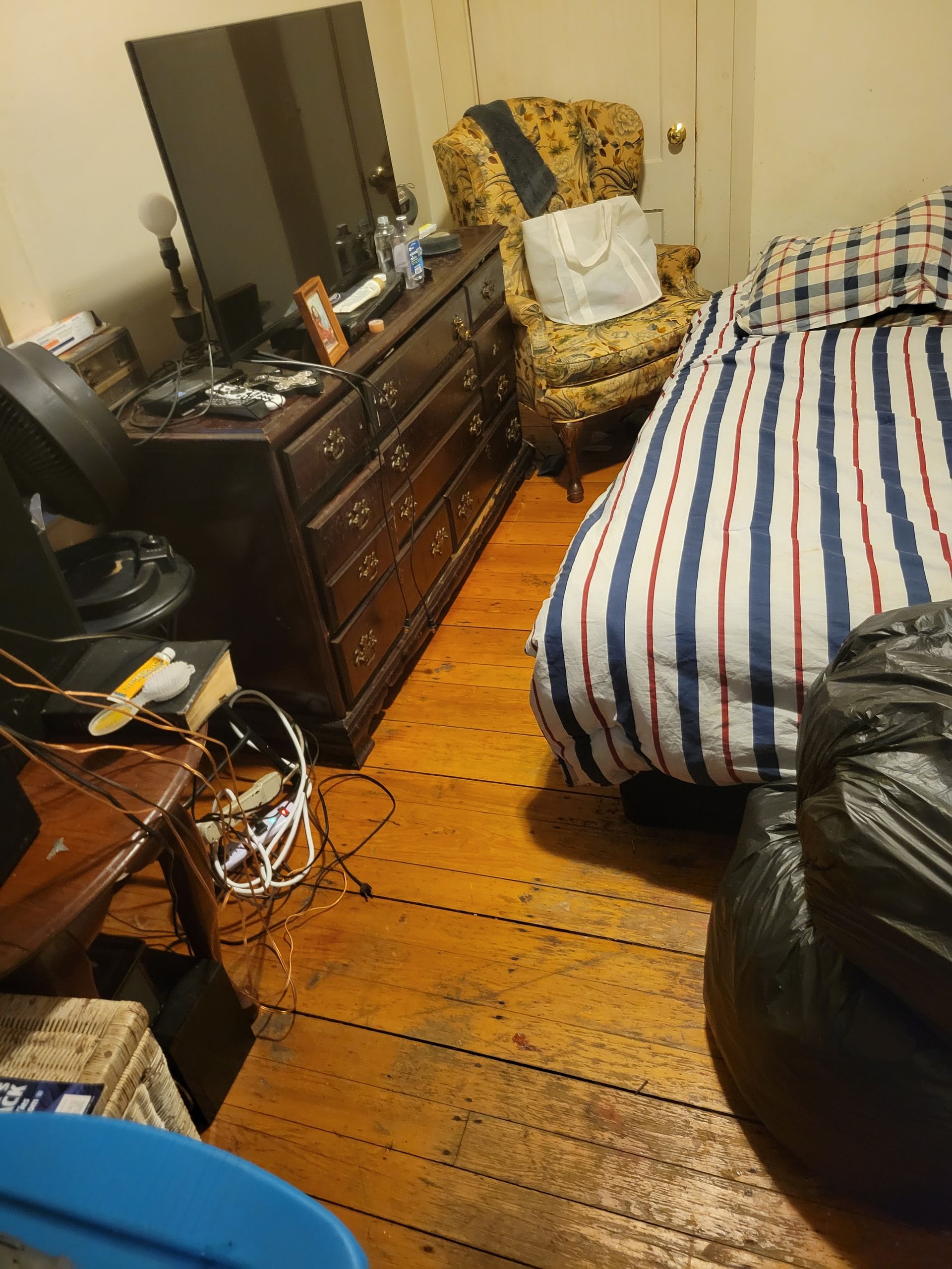 A bedroom with a bed a chair and a dresser