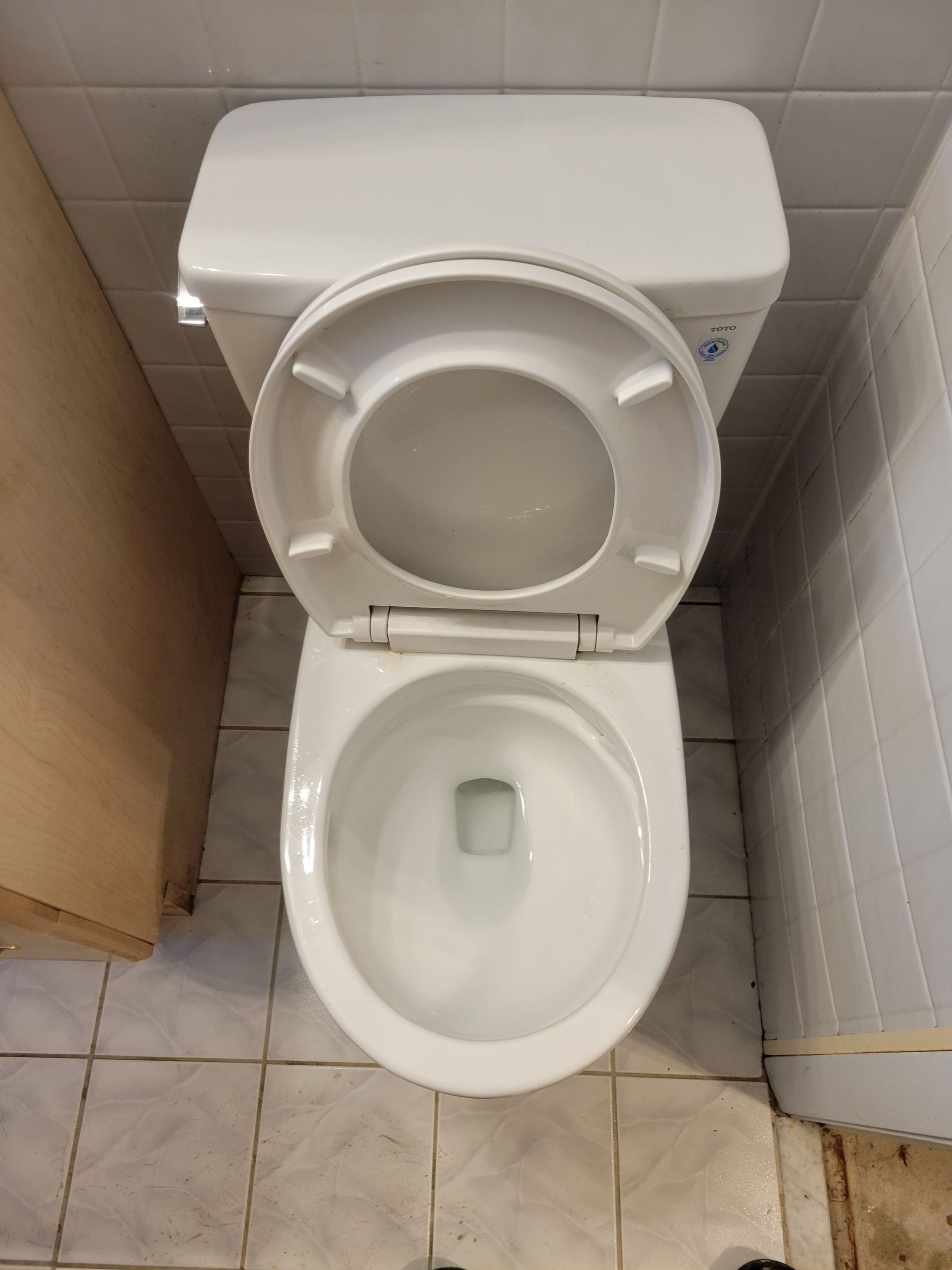 A white toilet with the lid open in a bathroom
