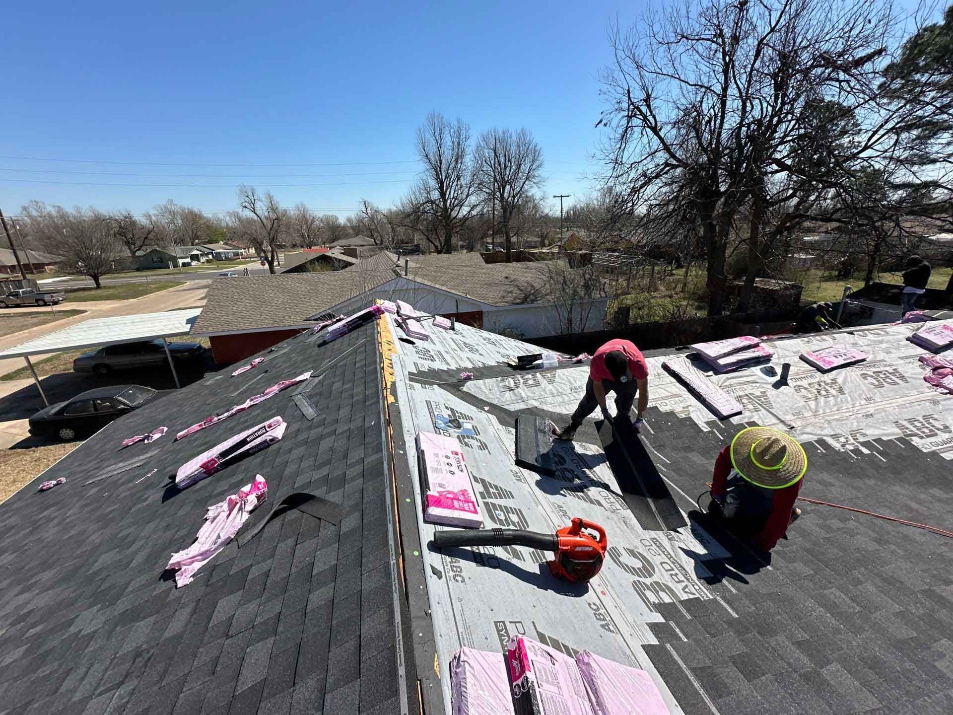 A man is working on the roof of a house.