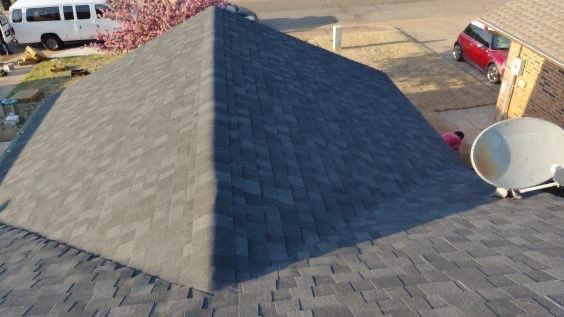 View from above of a dark grey shingled roof with a triangular shape.