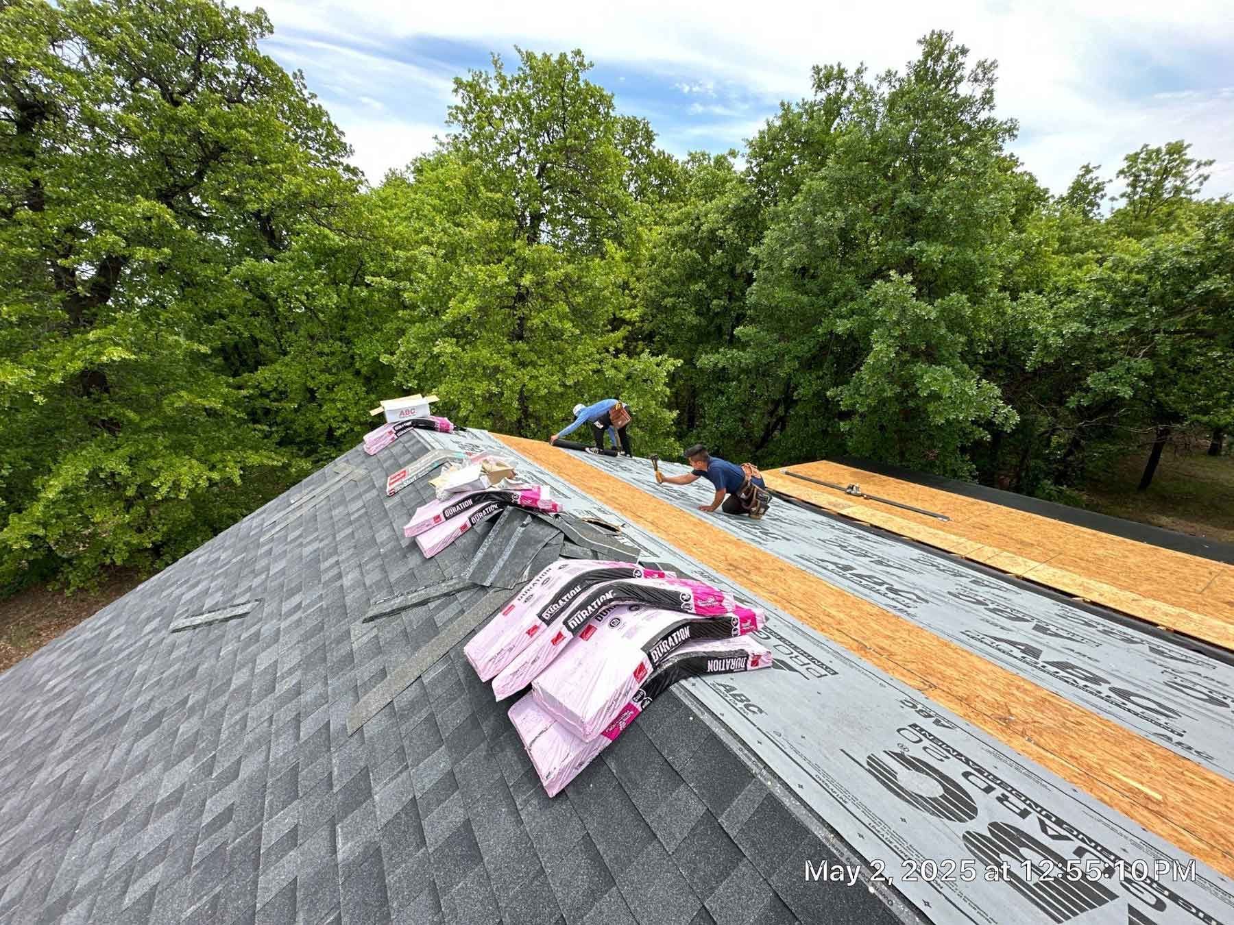 A group of men are working on the roof of a house.