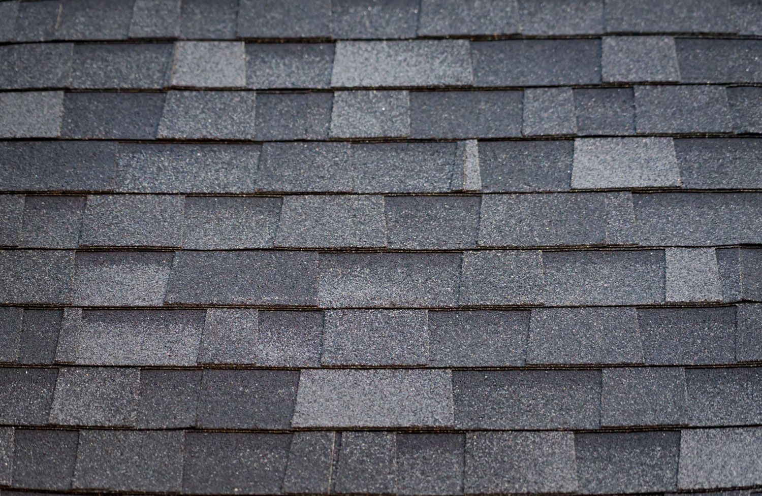 Gray asphalt roof shingles in a close-up pattern