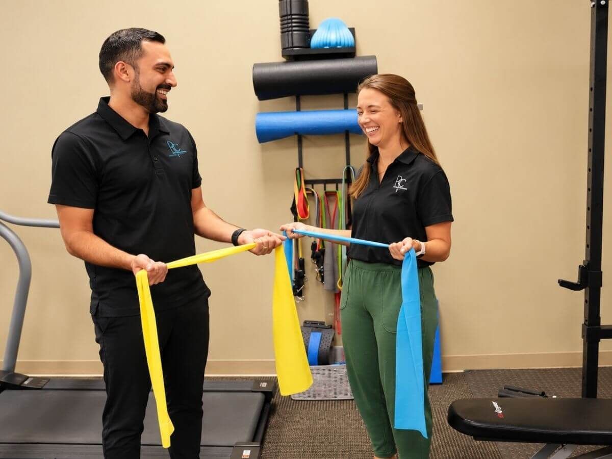 Chiropractors demonstrating resistance band exercises for shoulder pain care at Raise Chiropractic in Littleton, Colorado
