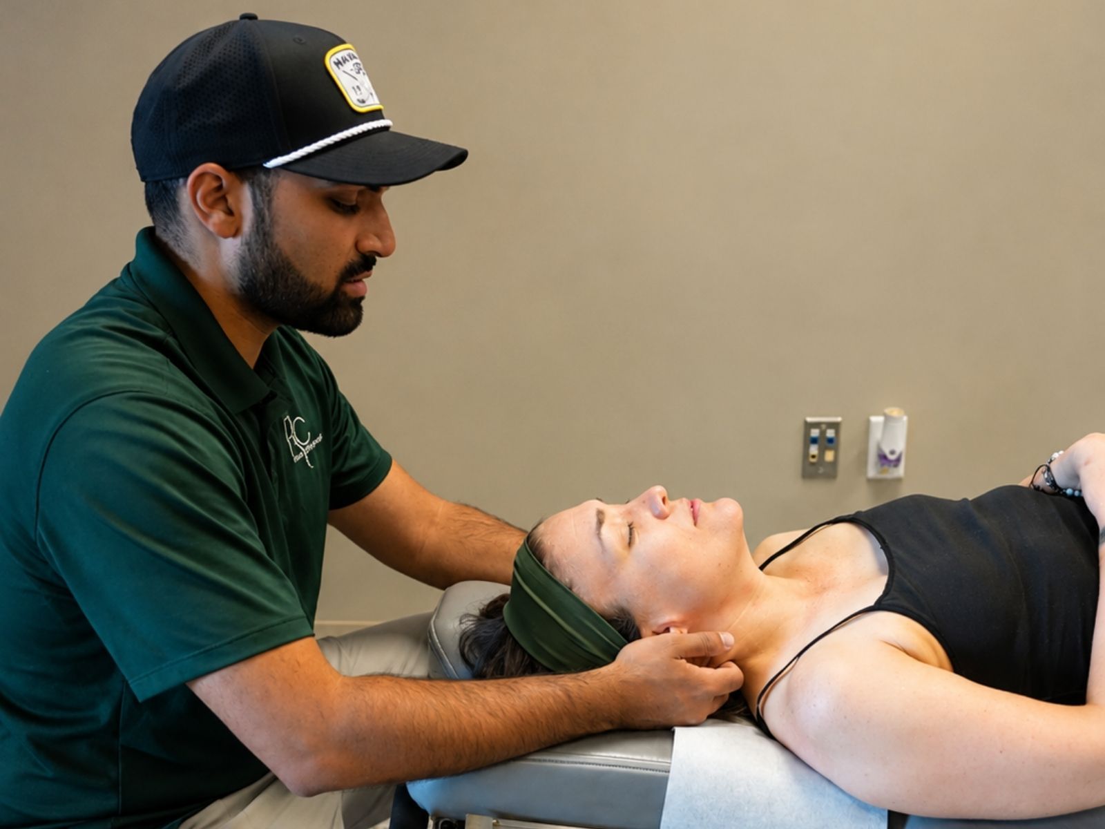 Dr. Neal Surani evaluating a patient's neck during auto accident injury chiropractic care at Raise Chiropractic in Littleton, Colorado