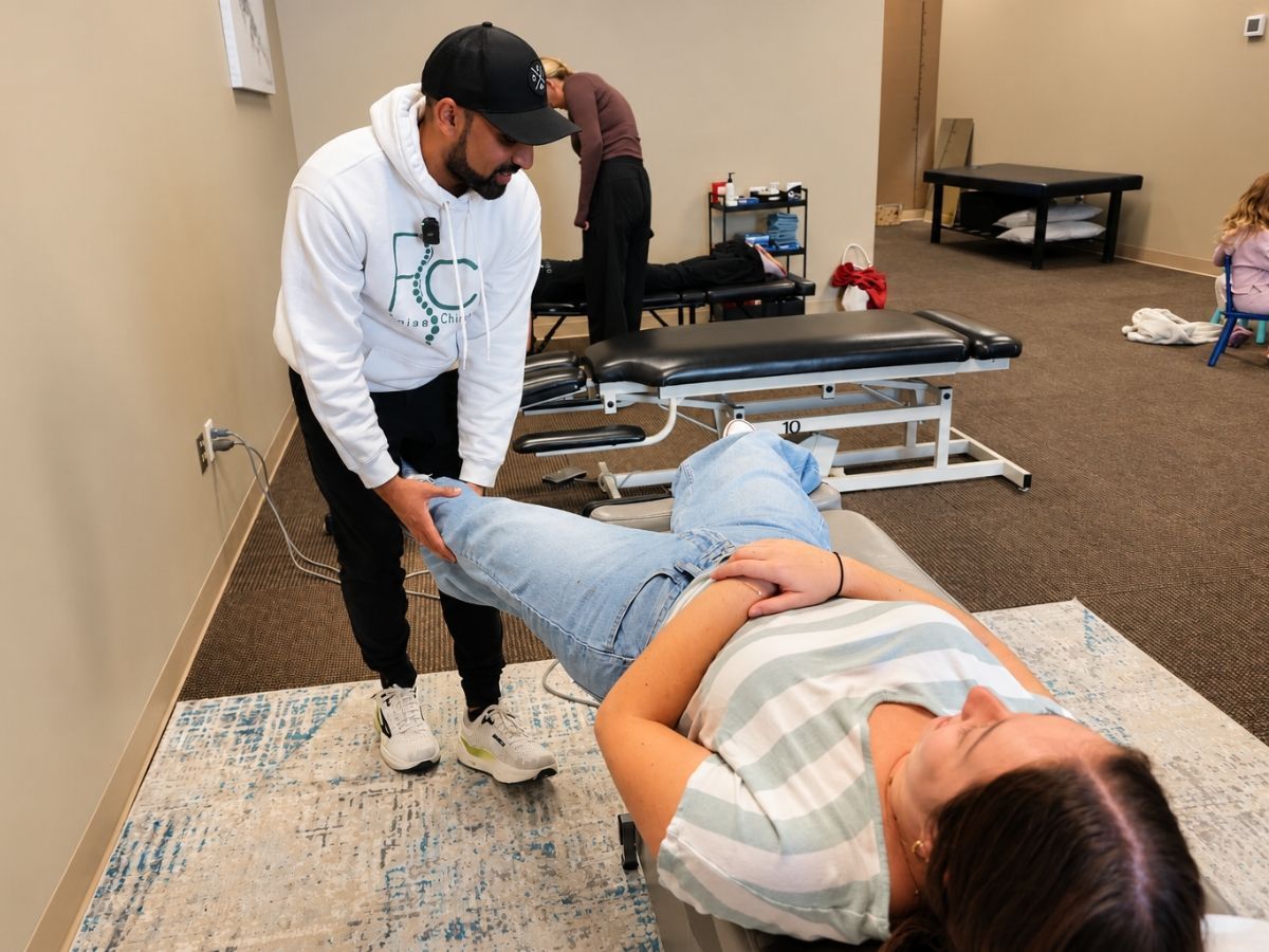 Dr. Neal performing a knee assessment on a female patient at Raise Chiropractic in Littleton, Colorado