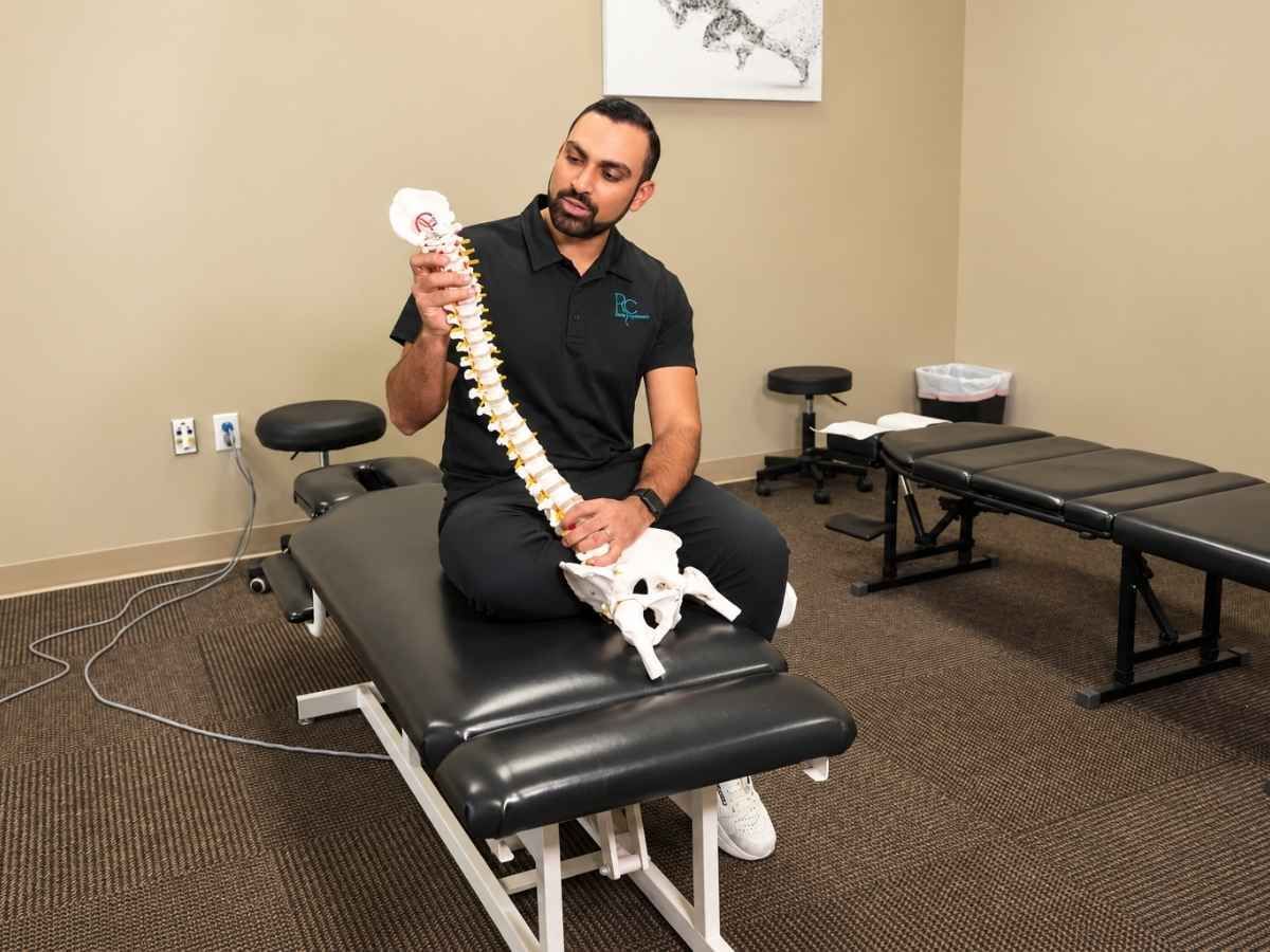 Raise Chiropractic provider demonstrating spinal anatomy with a spine model for herniated and bulging disc care in Littleton, Colorado