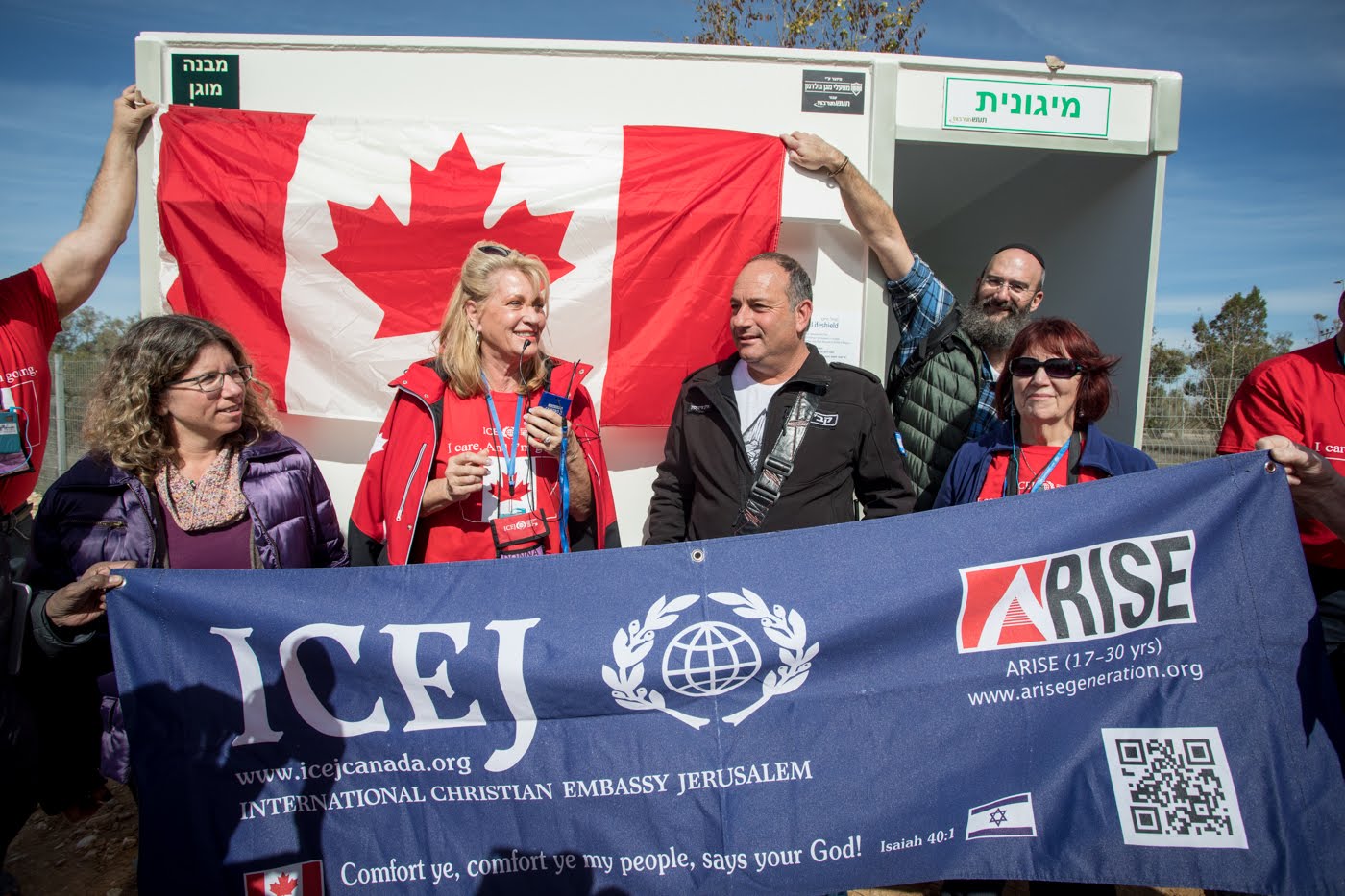 A group of people holding a banner that says icej