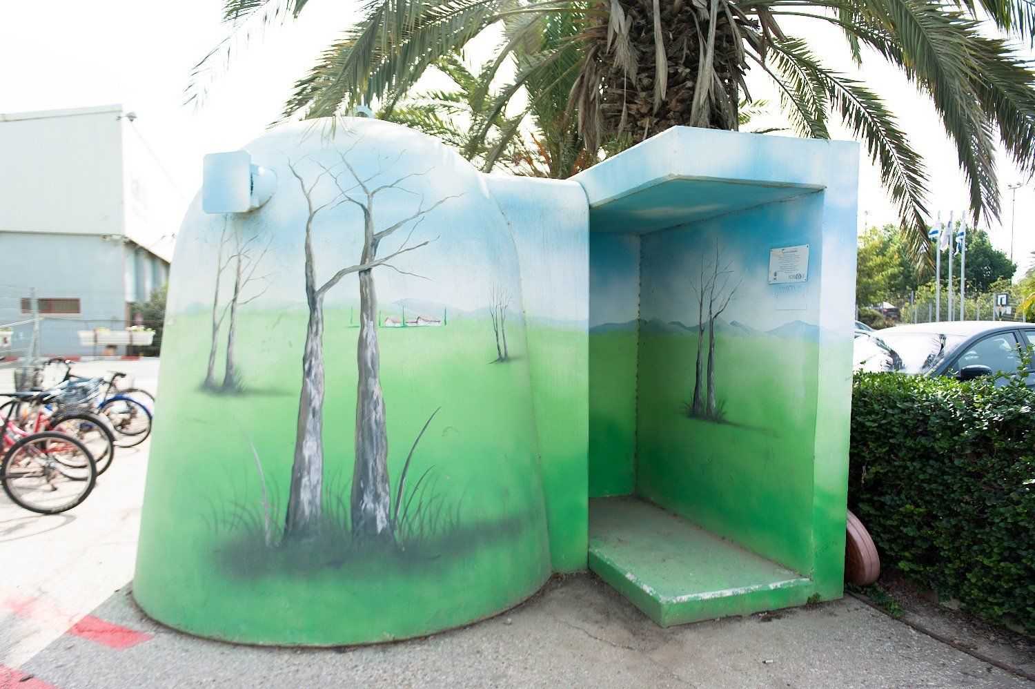 A green and blue sculpture with trees painted on it