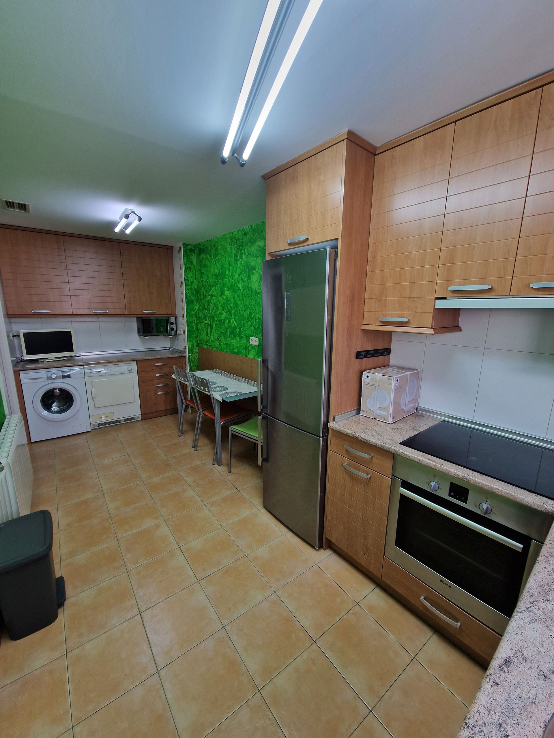 Cocina luminosa con suelo de baldosas, armarios de madera