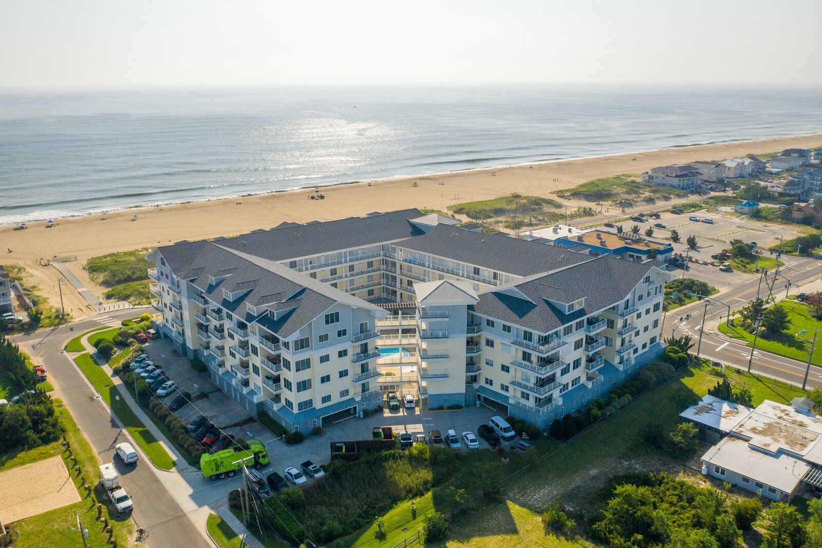 Aerial view of a modern beachfront apartment complex beside a sandy beach and ocean