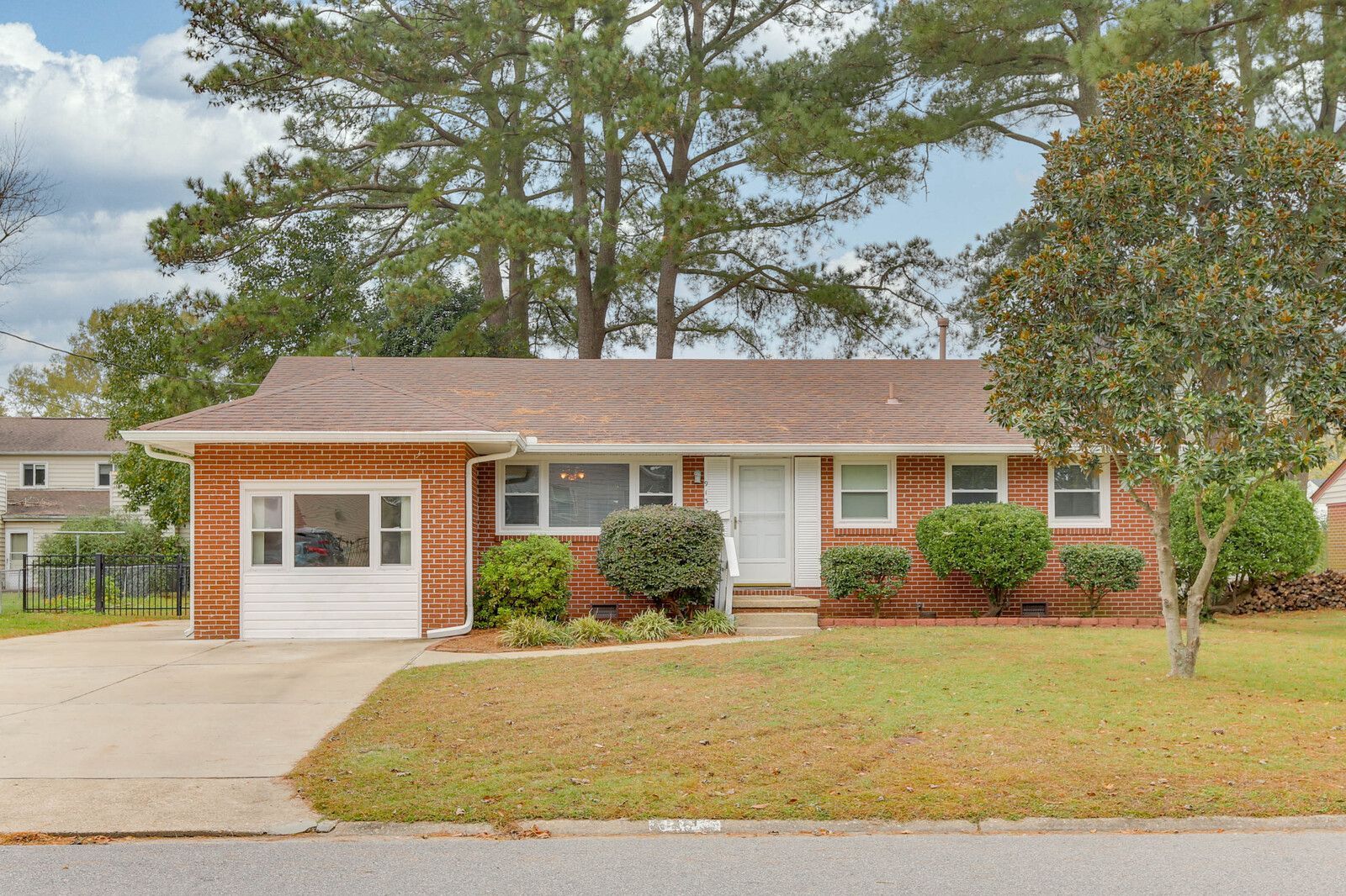 Single-story brick house with garage, white trim, and a front lawn