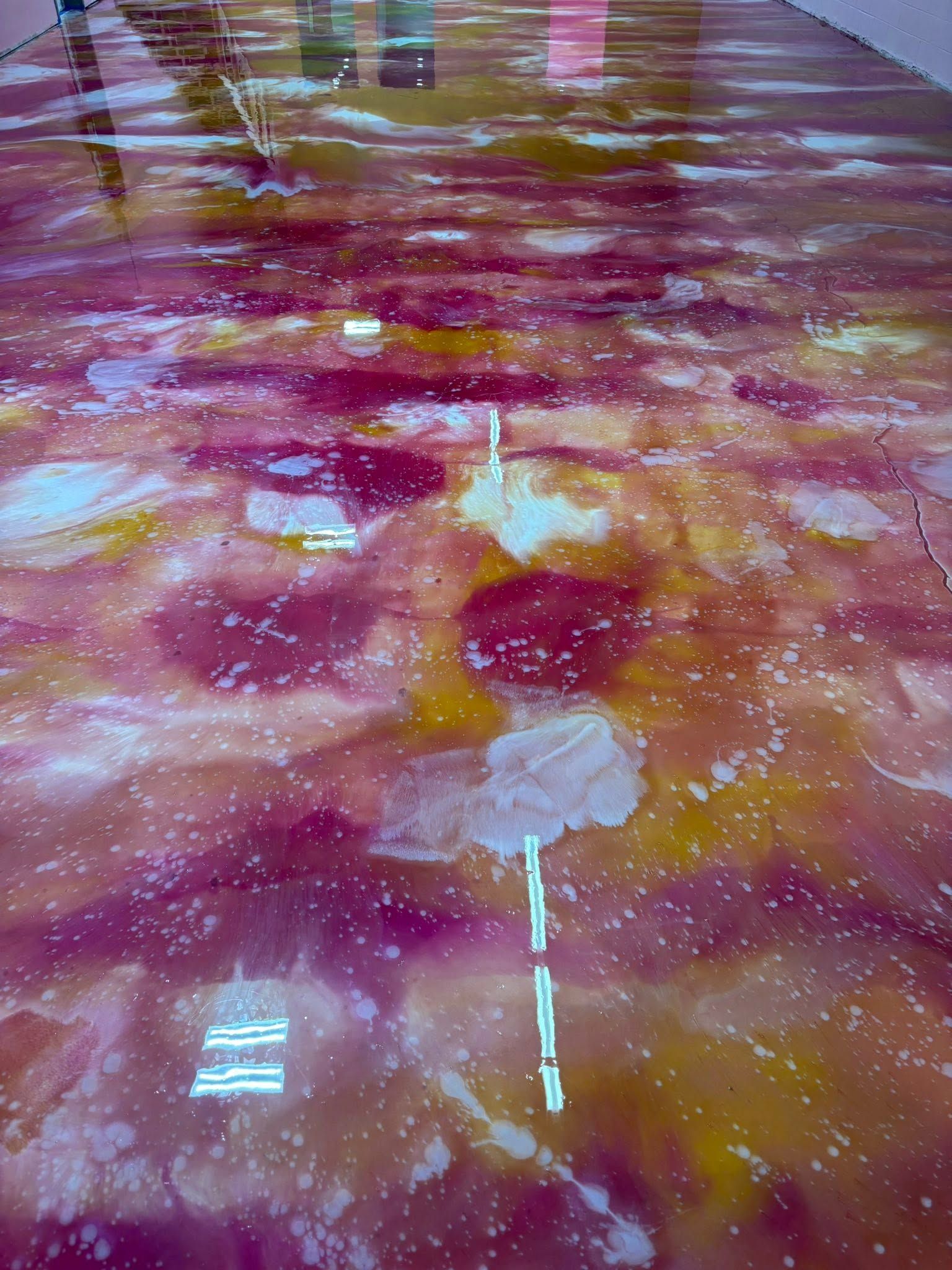 Abstract pink, purple, and gold marbled surface with a glossy sheen and white streaks