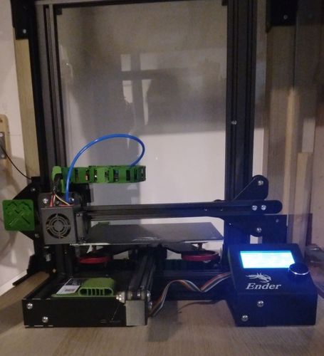 3D-printer op een bureau met een verlicht touchscreen-bedieningspaneel en een groene filamenthouder.