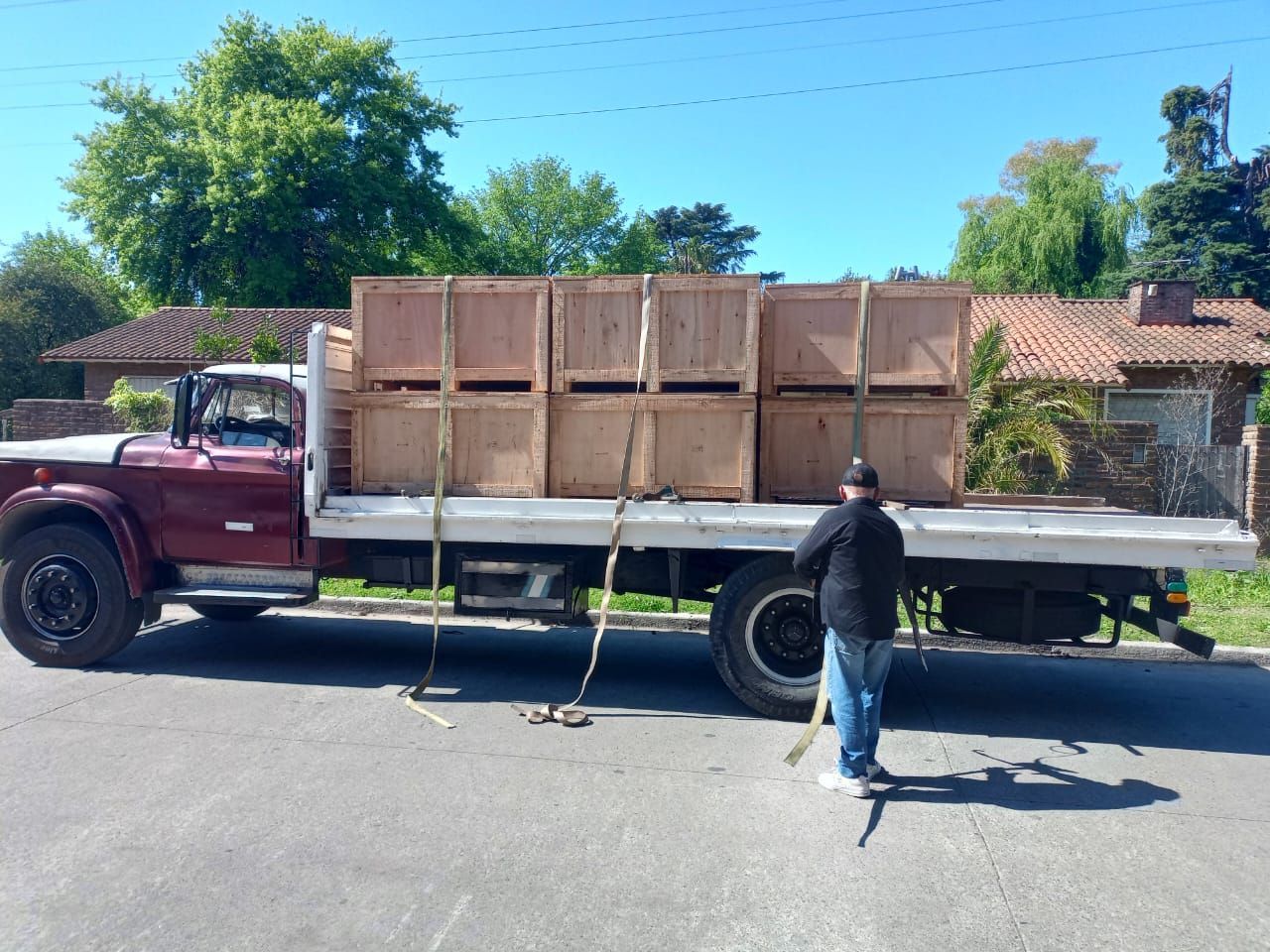 Una persona asegura cajas de madera en la parte trasera de un camión 