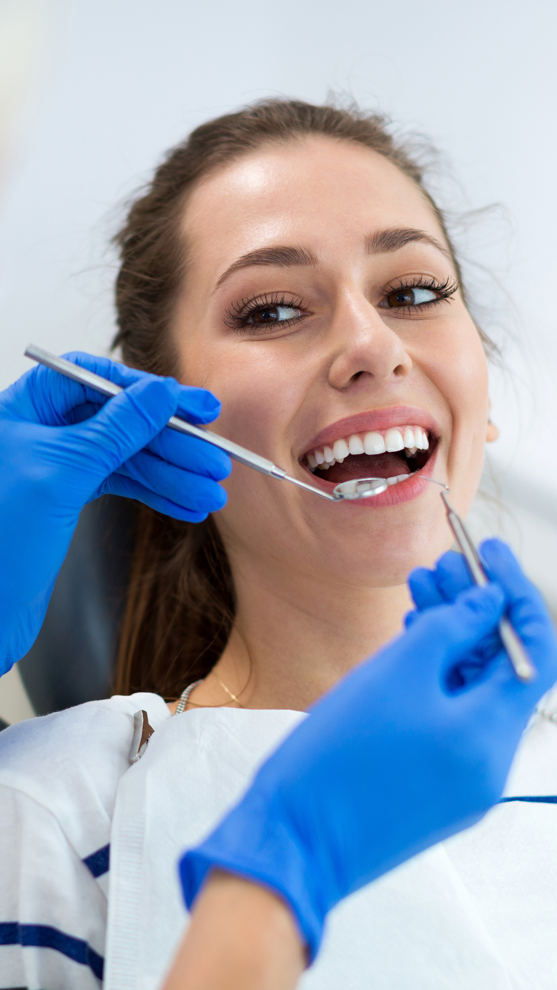 A woman is getting her teeth examined by a dentist.