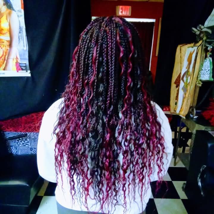 A woman with red braids is standing in front of an exit sign